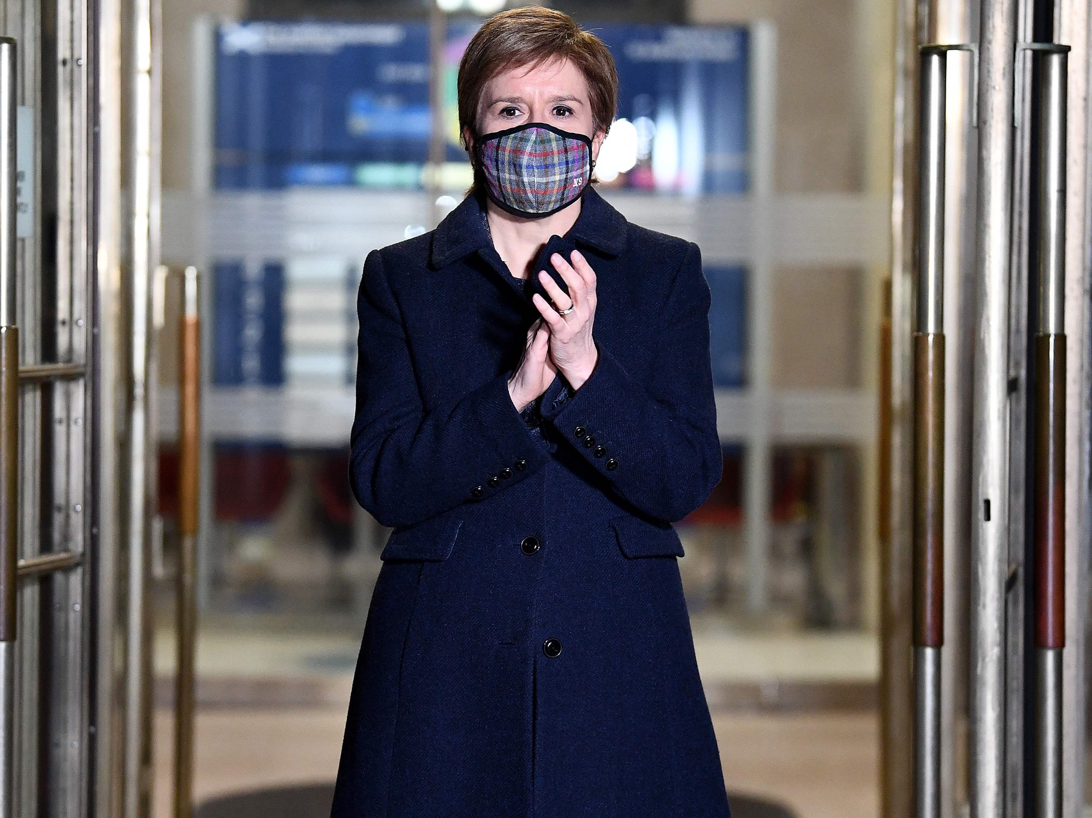 Scotland's First Minister Nicola Sturgeon claps outside St Andrews House in Edinburgh