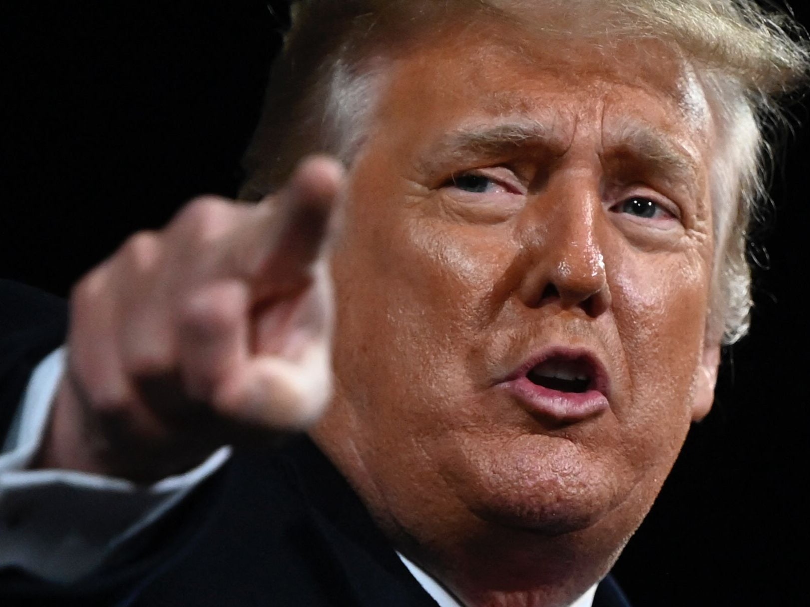 Former President Donald Trump points at the end of a rally to support Republican Senate candidates at Valdosta Regional Airport in Valdosta, Georgia