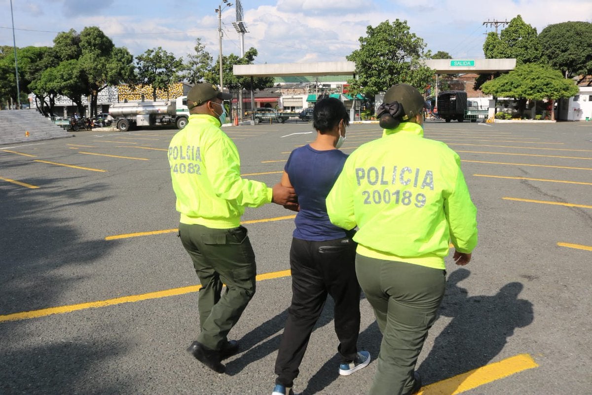 Colombian police are shown with the detained murder suspect Mariluz Mosquera.