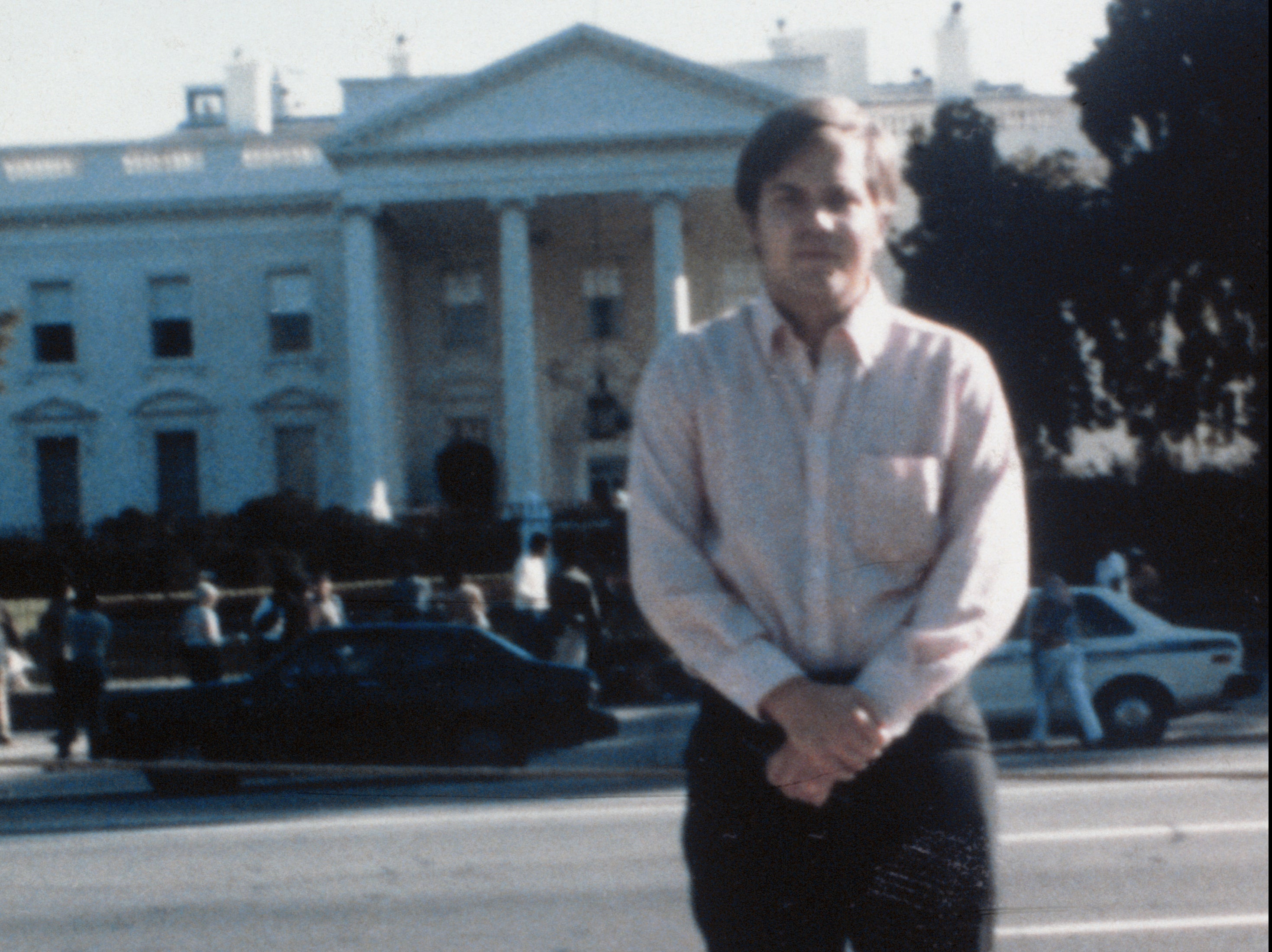 John Hinckley Jr poses outside the White House, Washington DC, in 1980