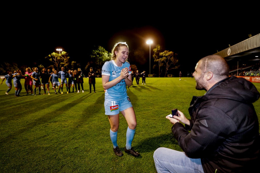 Team-mates watch on as Dobson accepts a proposal