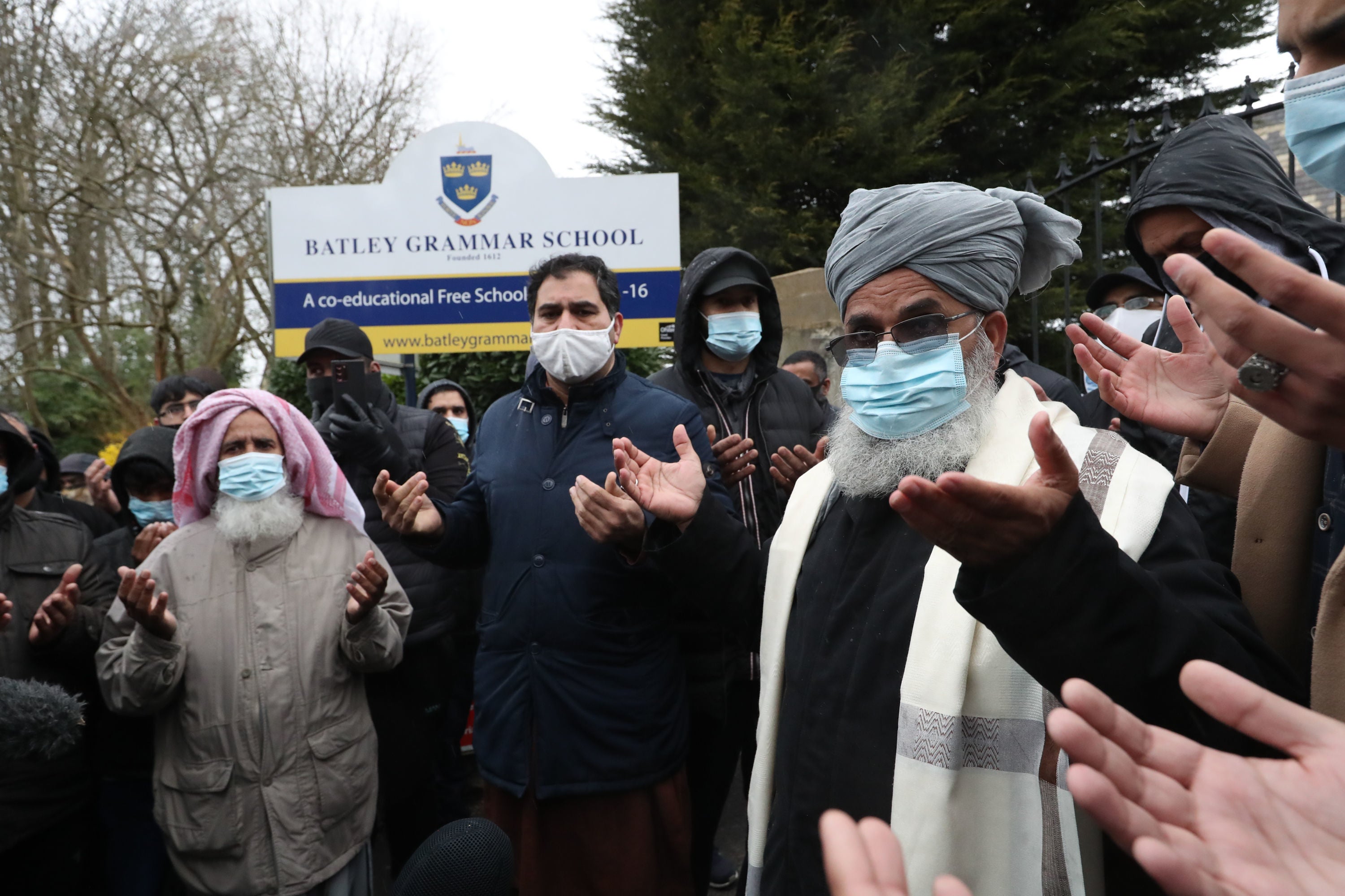 Protesters take part in a prayer outside Batley Grammar School in Batley, West Yorkshire