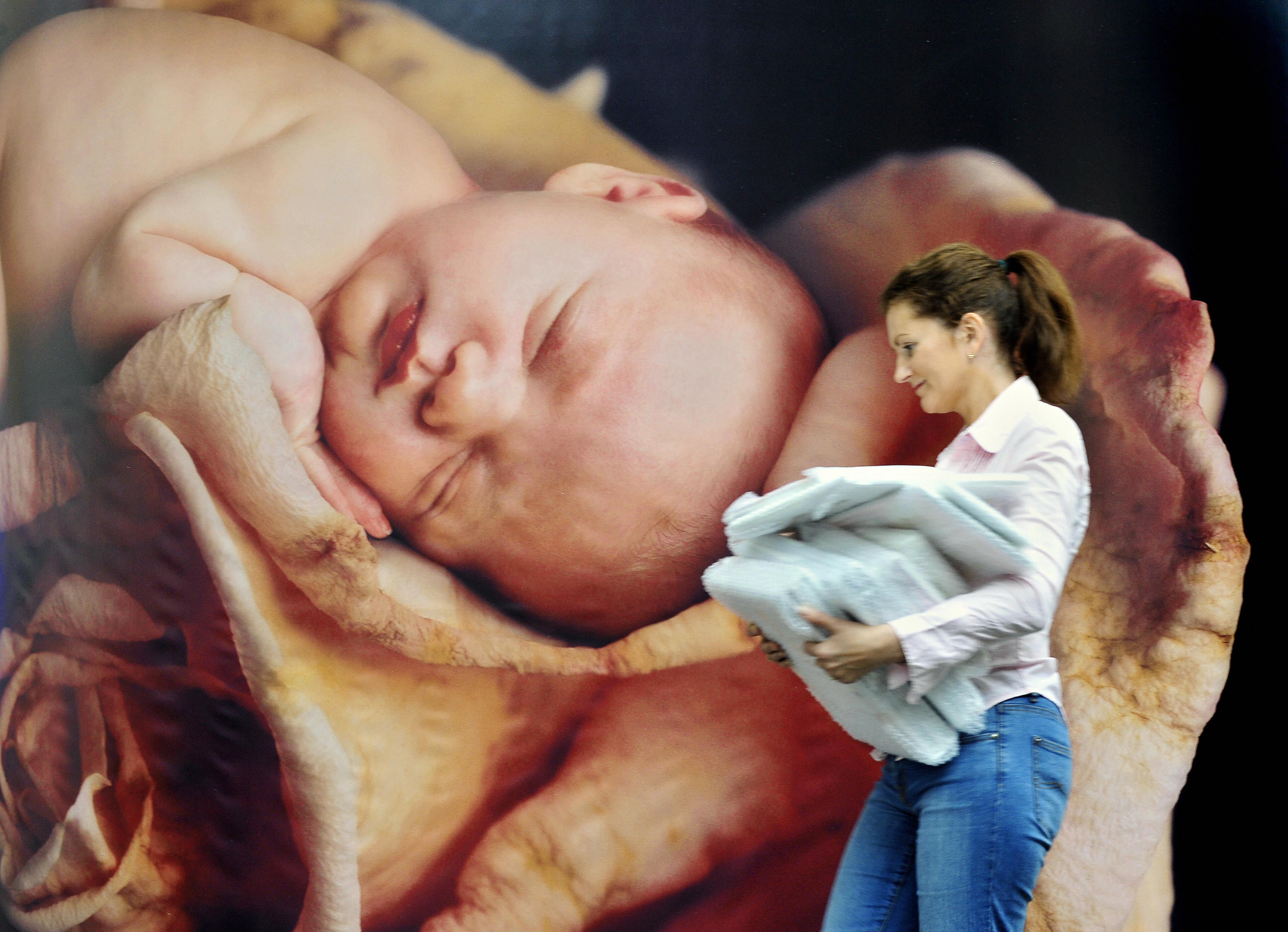 A woman walks past a poster featuring a picture by Geddes at the Frankfurt Book Fair in 2008