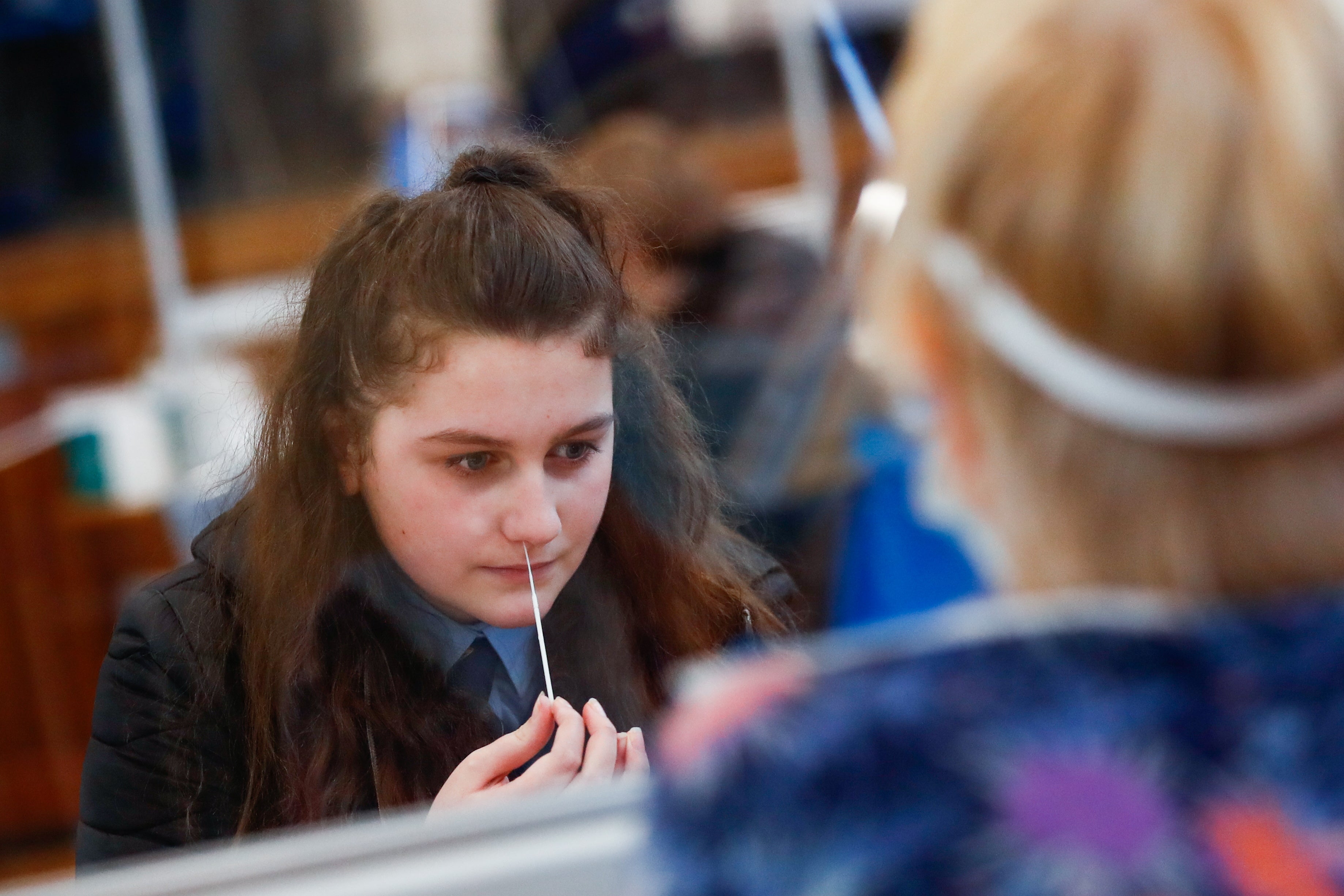 A student takes a lateral flow test at school