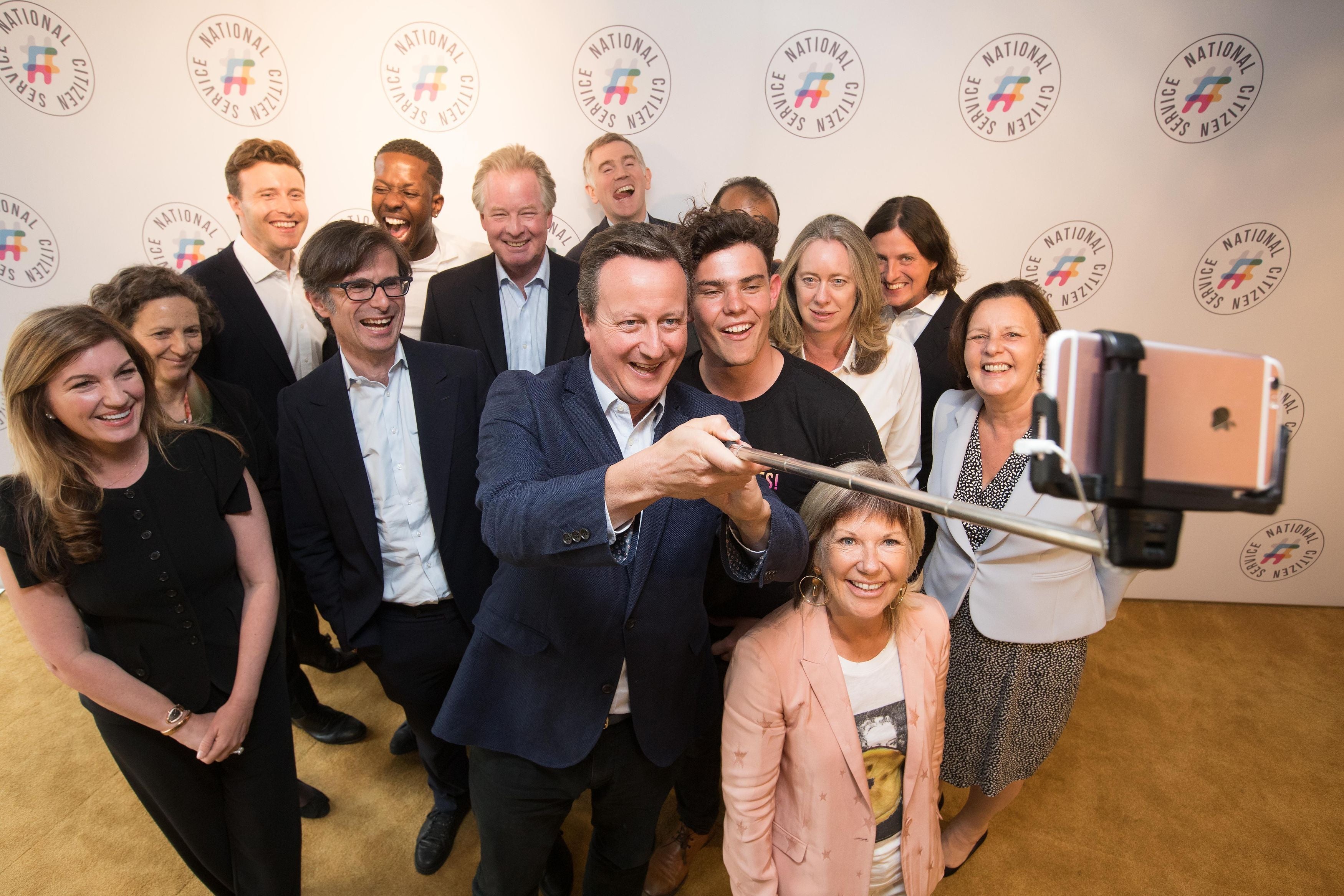 David Cameron, chair of patrons for National Citizen Service (NCS), helps arrange a selfie with the new board of patrons and NCS grad Cameron Duncan Lyon, 18, at Google HQ in London, in July 2017