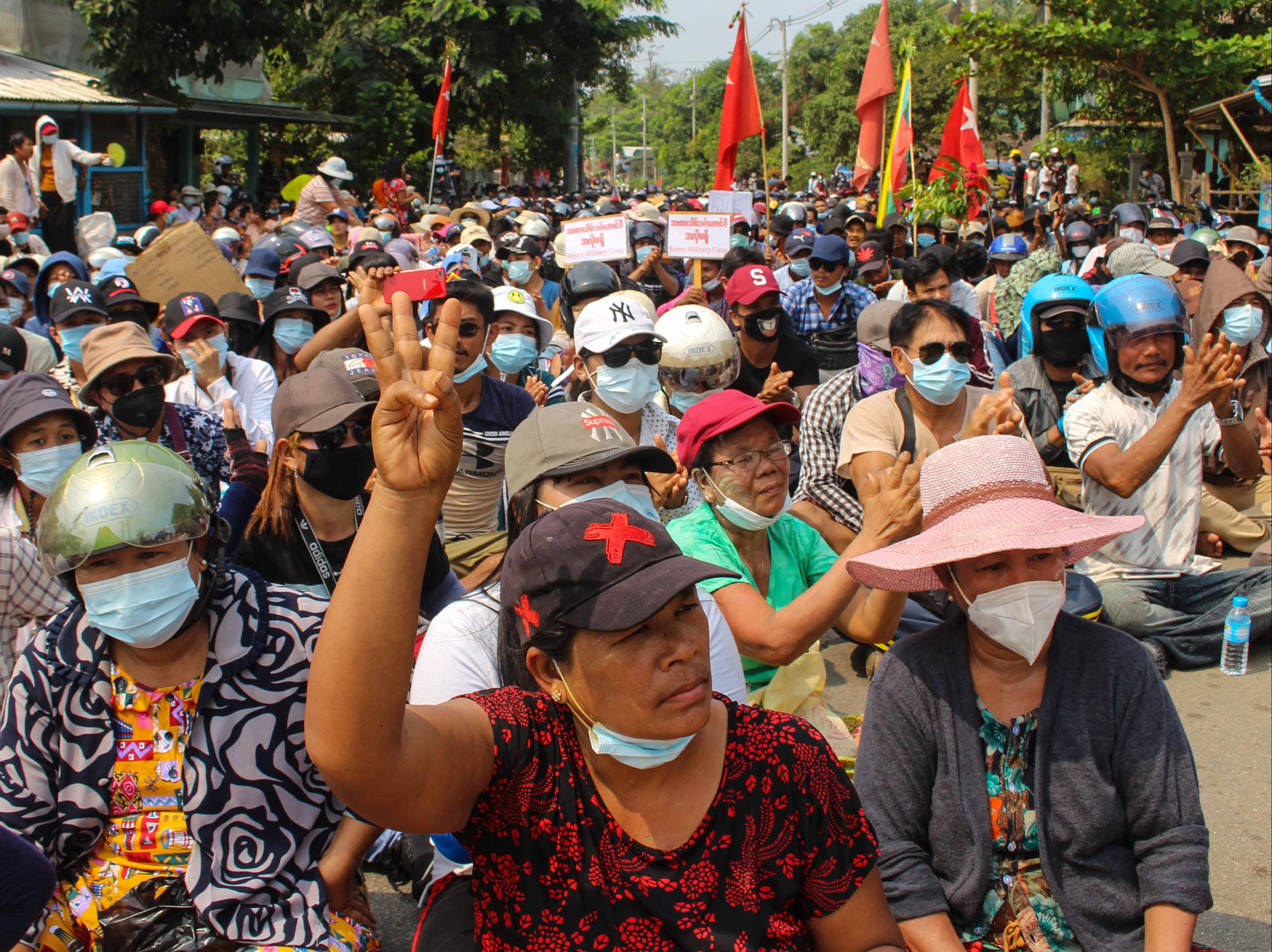 A protester makes the three-finger salute during a sit-in demonstration in Dawei