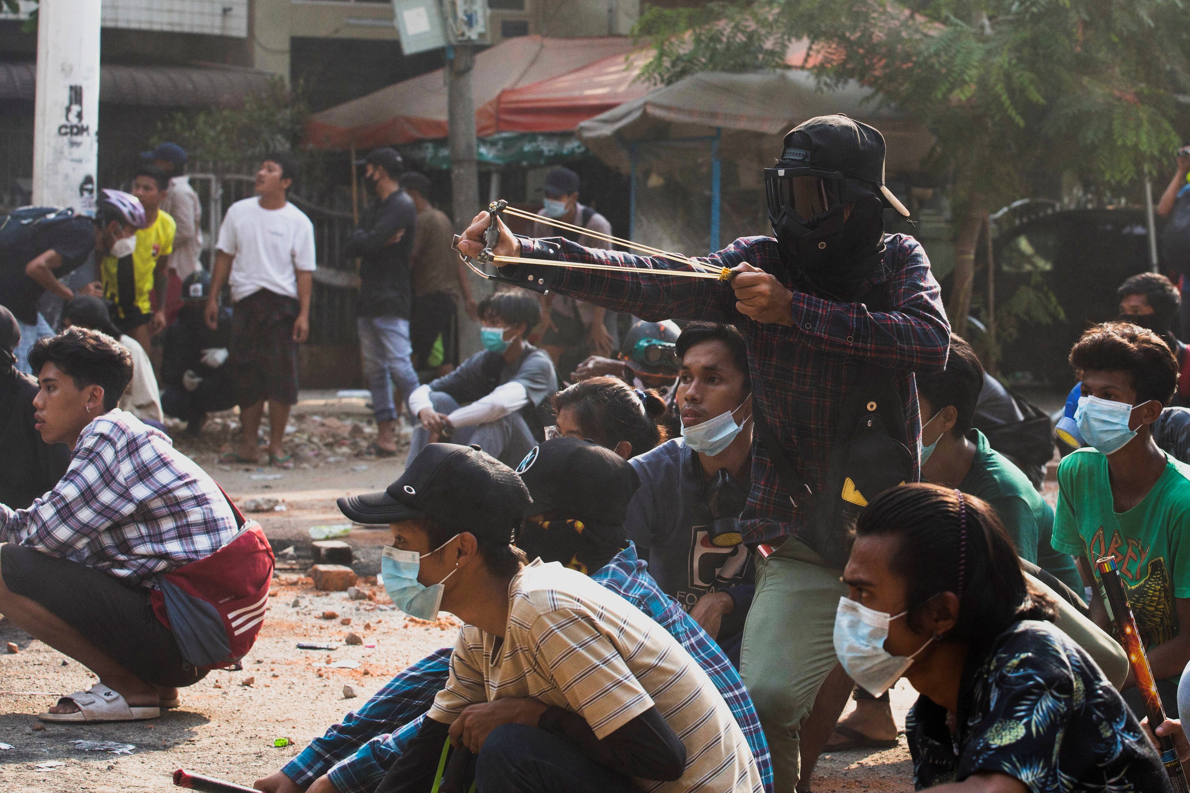 A man uses a slingshot during a protest against the military coup, in Yangon, Myanmar, on Sunday