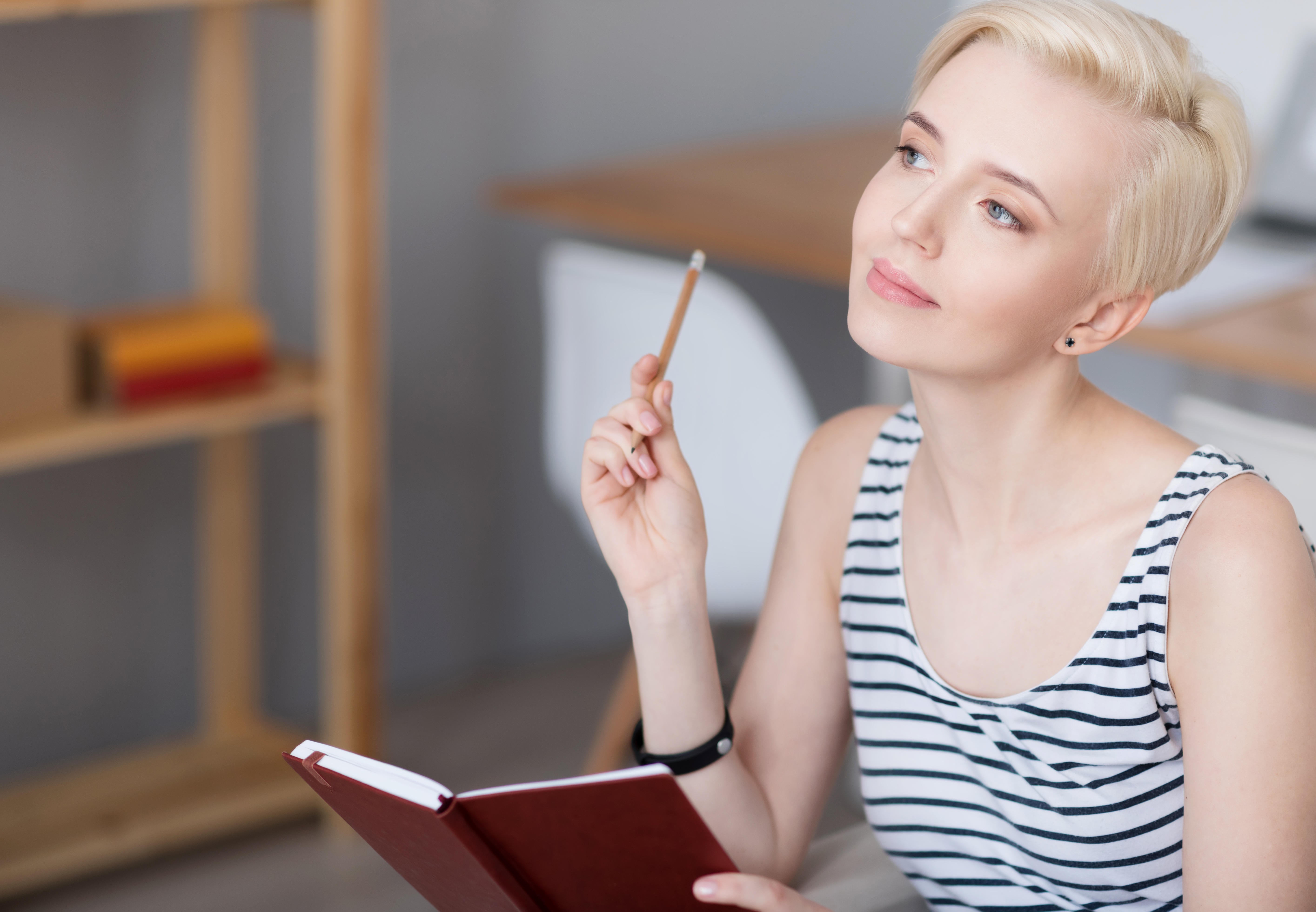 Woman thinking and holding diary