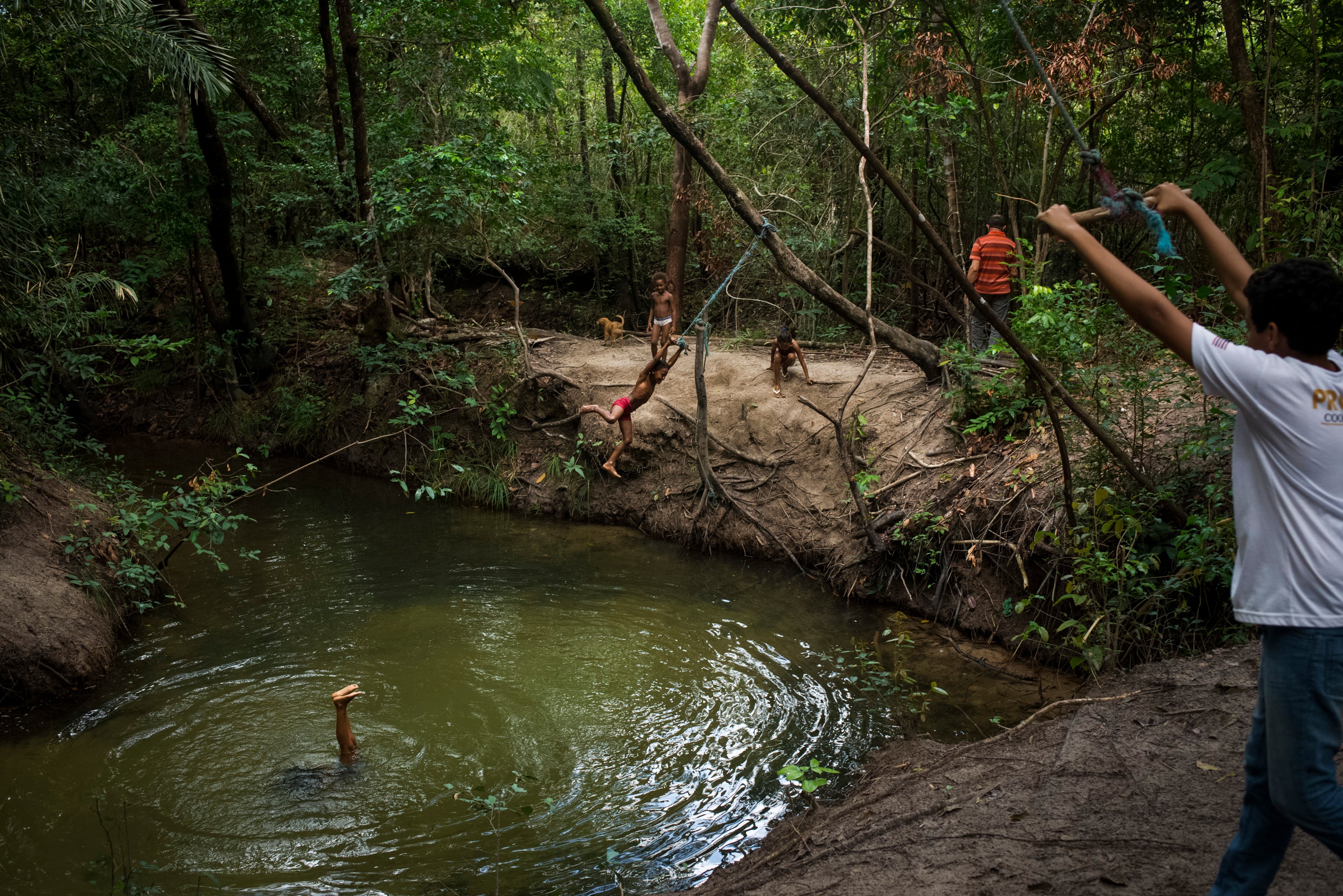 Pinheiro’s relatives ​​play in a river near their home in Alcantara