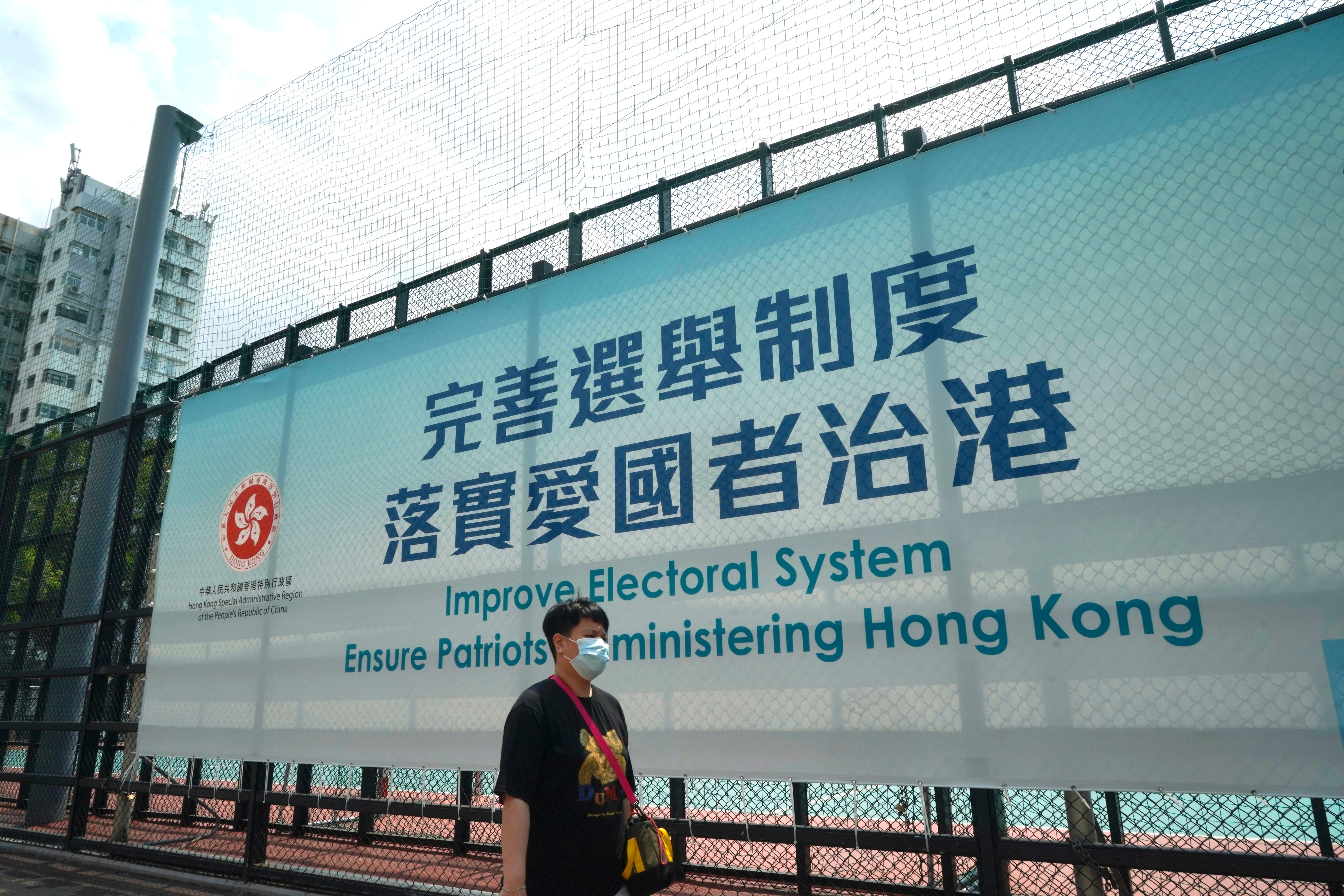 Man walks past a government advertisement to promote the new Hong Kong electoral system reform, in Hong Kong, 30 March, 2021