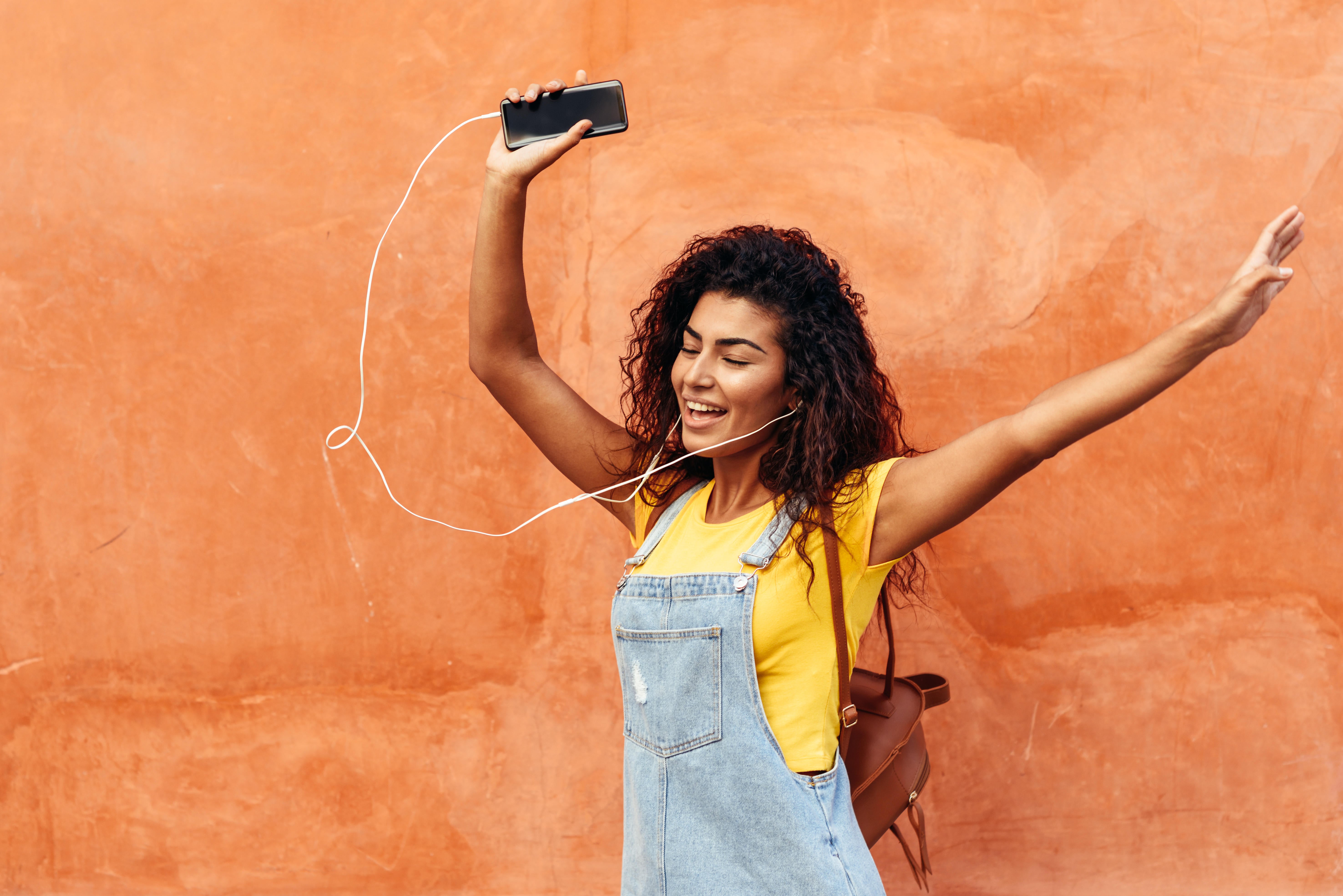 Woman listening to music with her arms in the air