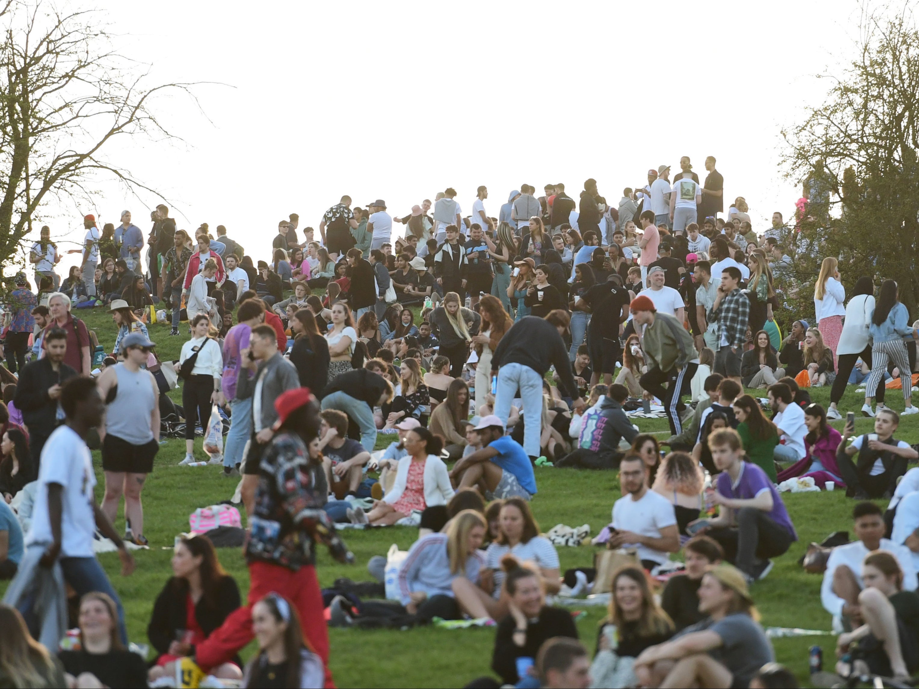 People enjoy the evening sunlight on Primrose Hill, north London