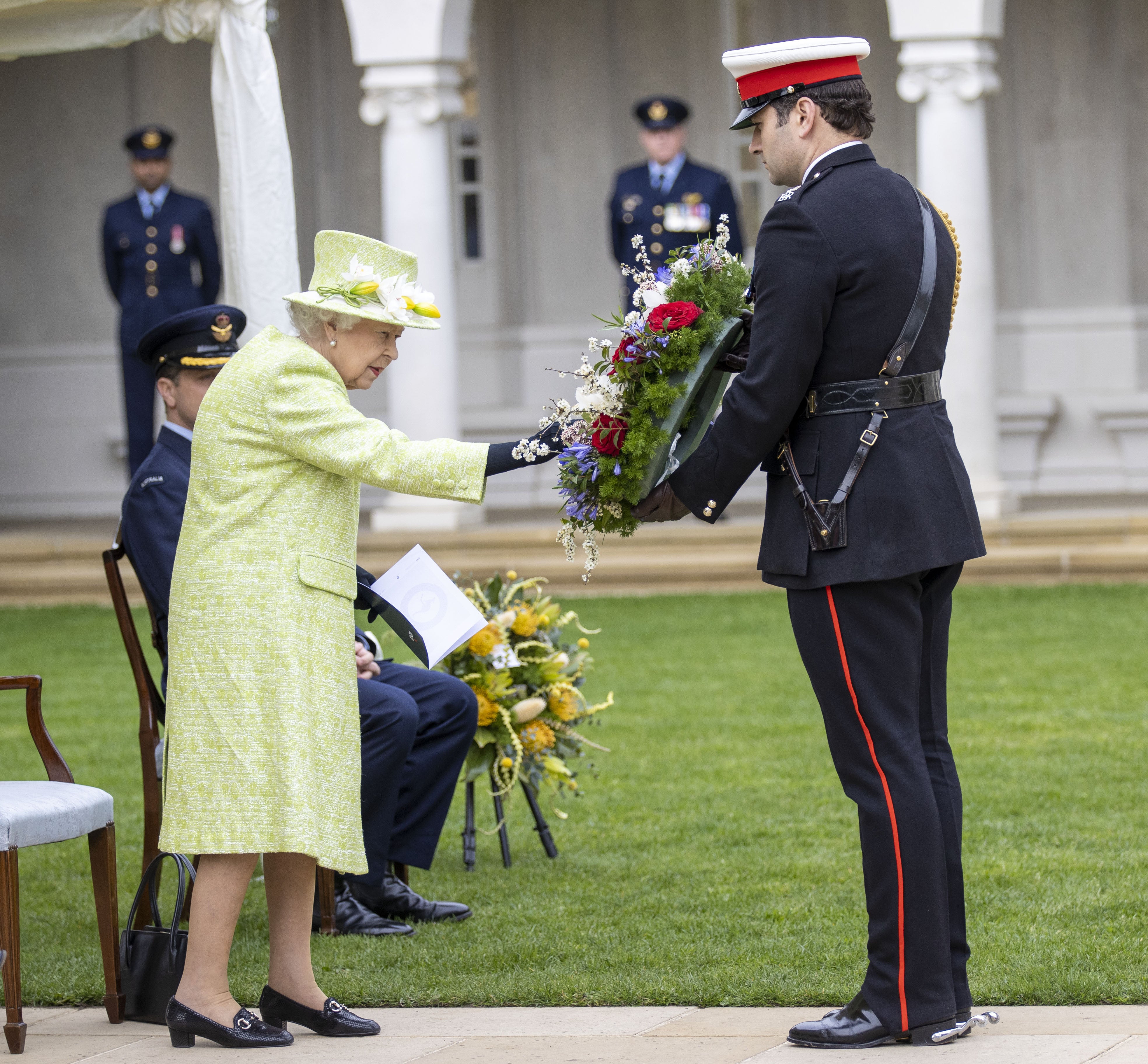 The Queen inspects a wreath during the service