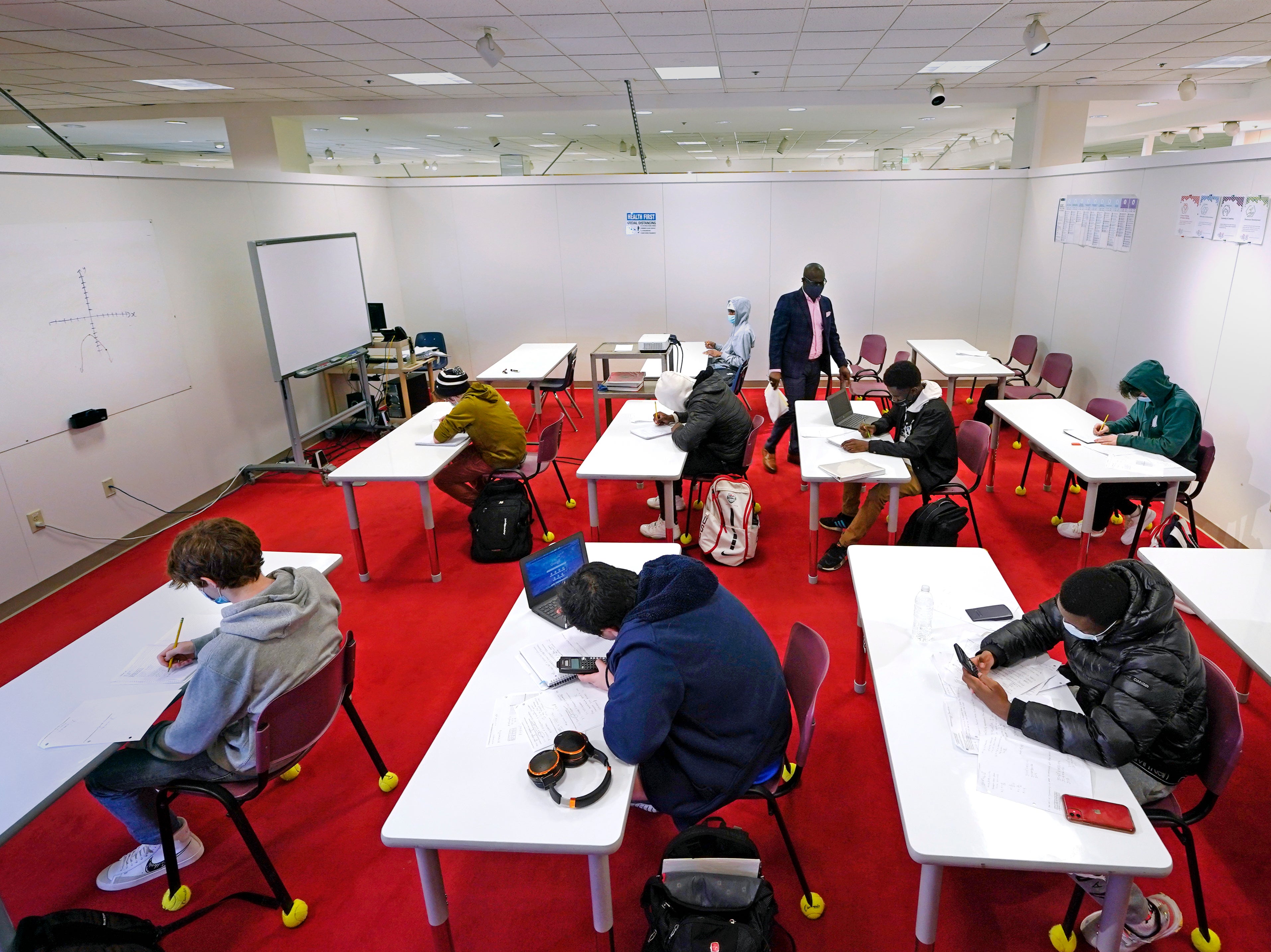 Math students calculate algebra equations in their classroom, which was built in the middle of a former department store, at Downtown Burlington High School on Monday, 22 March, 2021