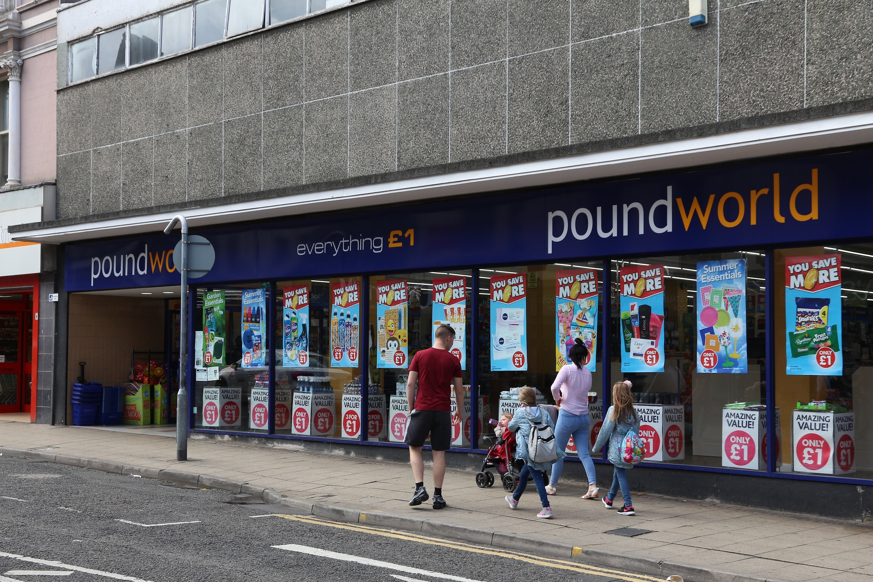 People walk by Poundworld discount store in Barnsley, UK