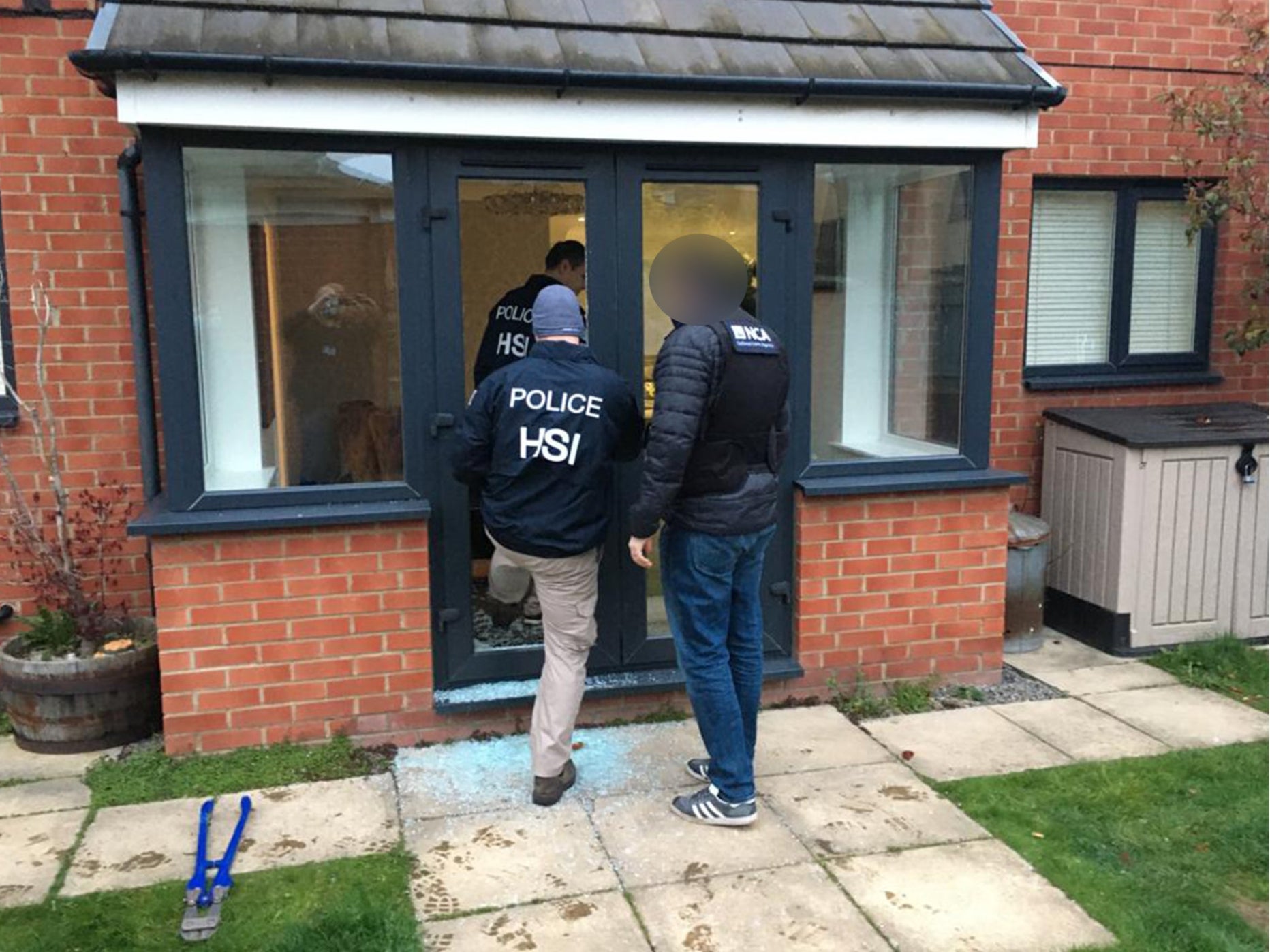 Police entering a property as part of an investigation into a gang selling large quantities of ecstasy around the world on the dark web