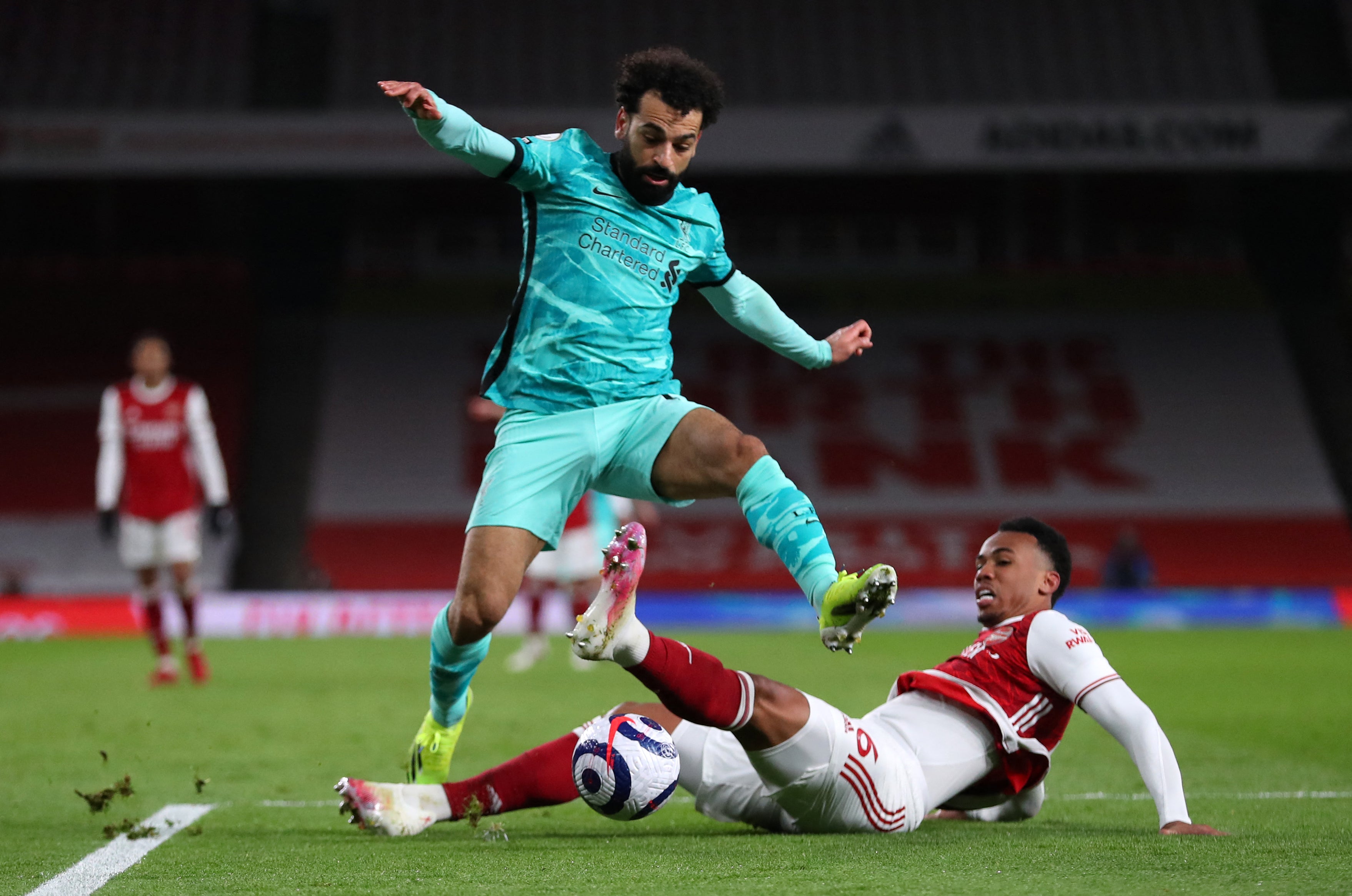 Liverpool’s Mohamed Salah jumps over a challenge from Arsenal’s Gabriel