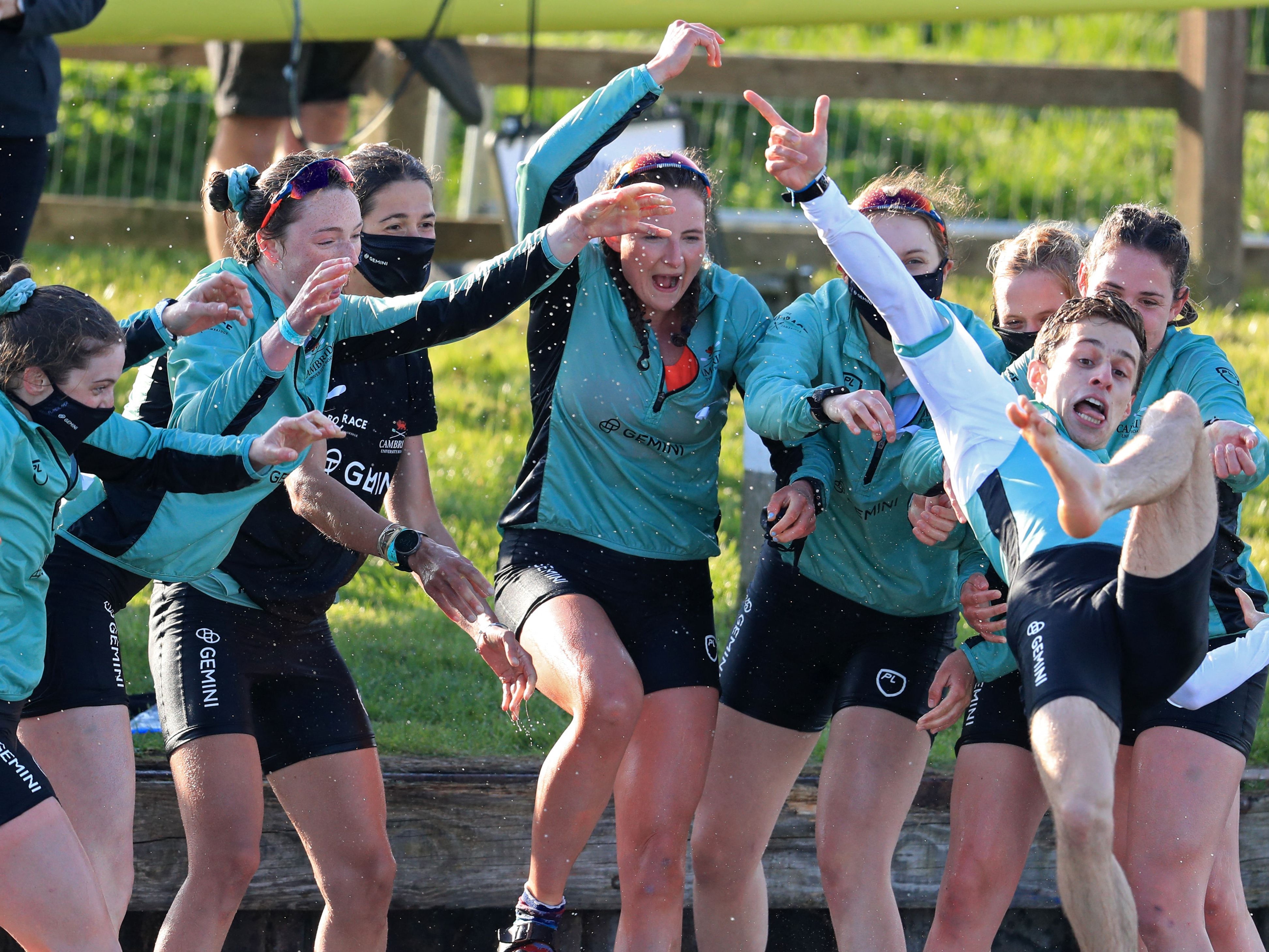 Cambridge cox Dylan Whitaker (R) is thrown into the river