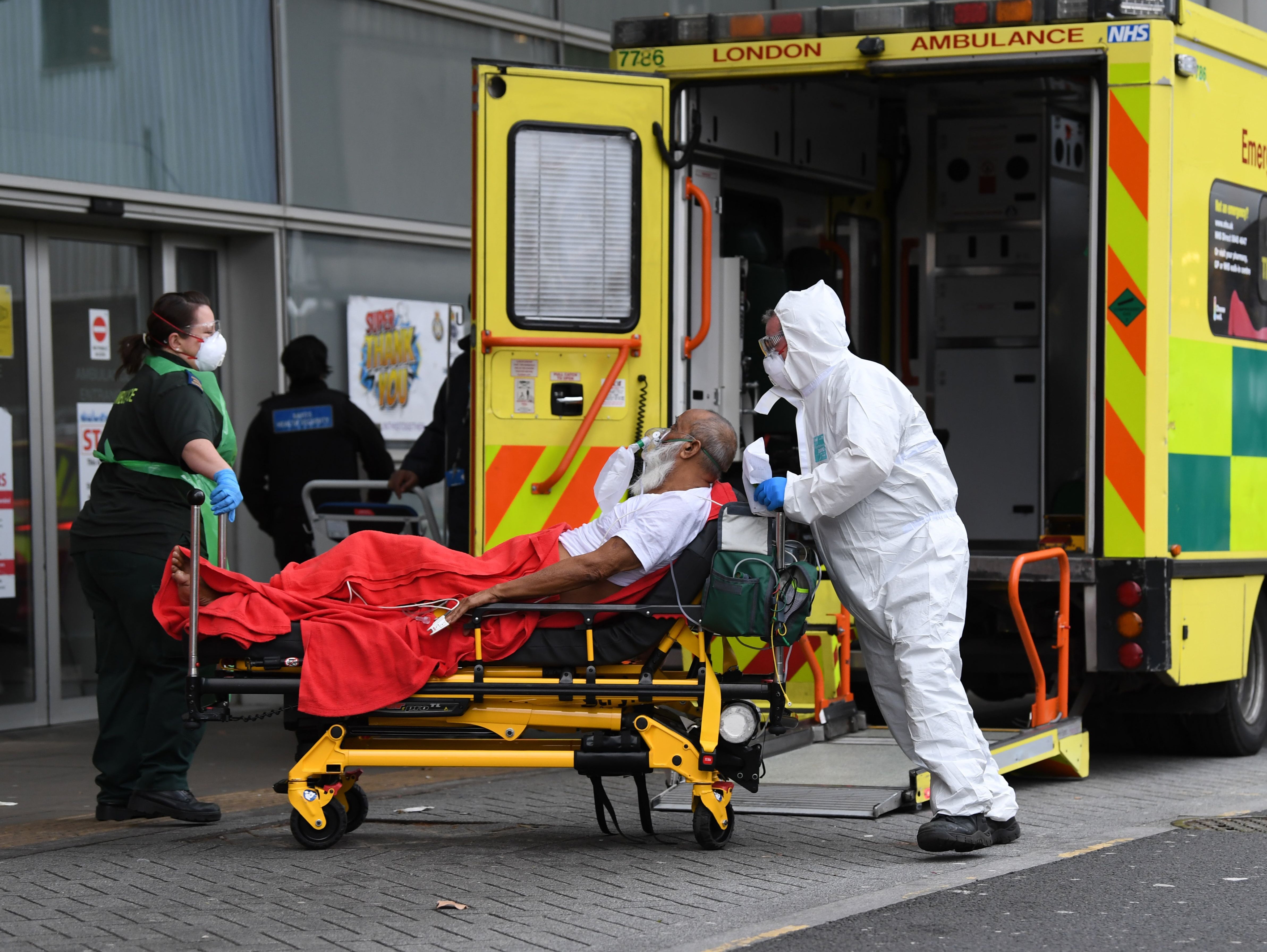 Paramedics wheel a patient from an ambulance into the Royal London Hospital