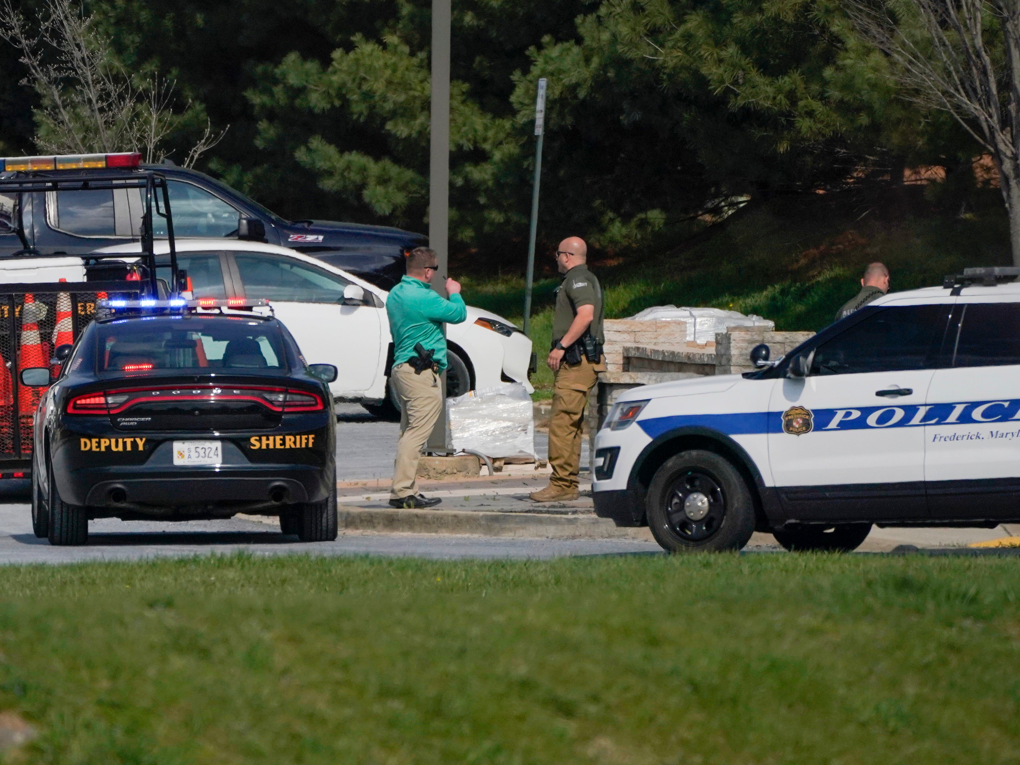 Police talk near the scene of a shooting at a business park in Frederick, Maryland, Tuesday, 6 April, 2021