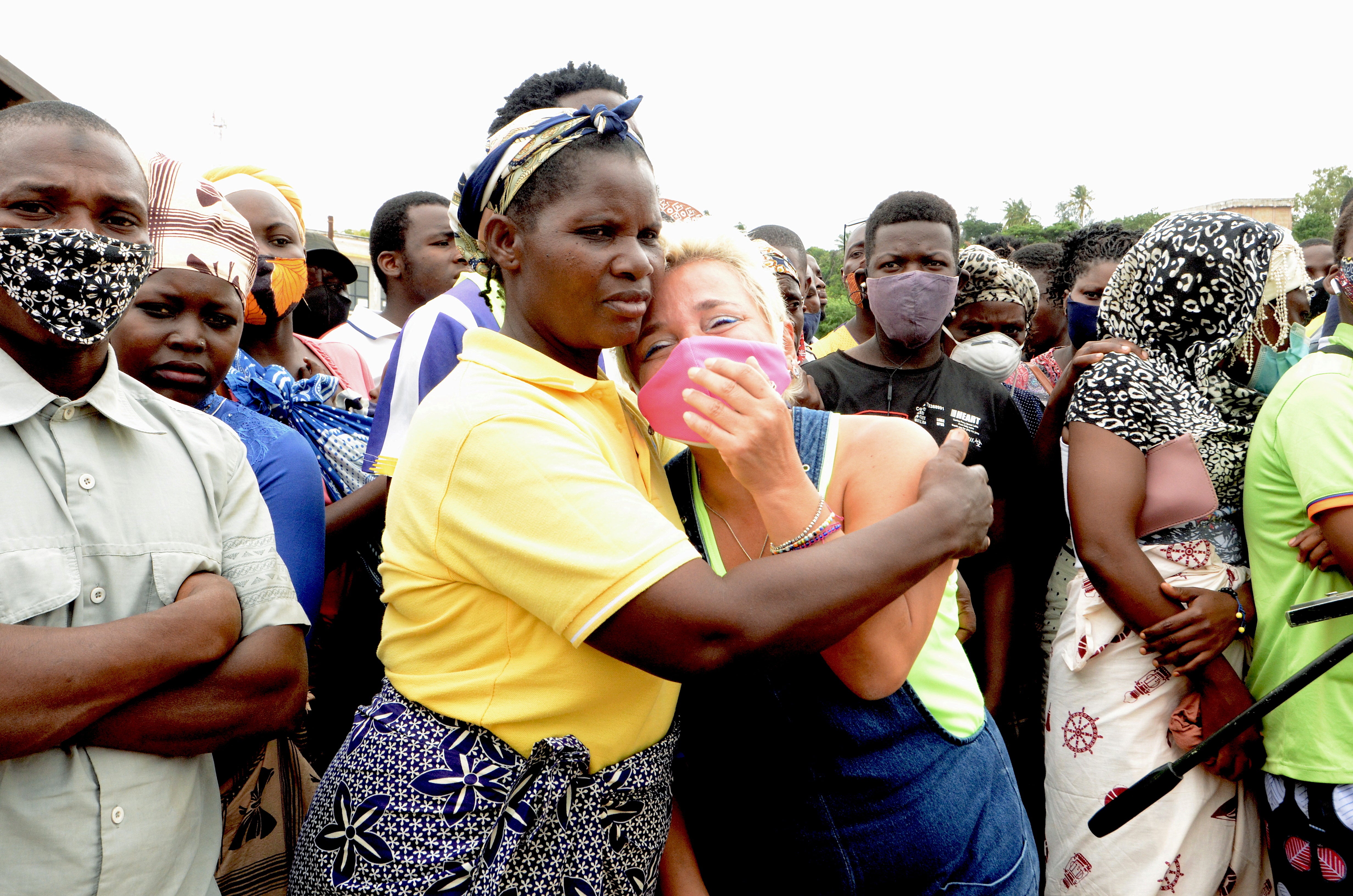 A woman is comforted by friends after a ship, carrying more than 1,000 people fleeing an attack claimed by Islamic State-linked insurgents on the town of Palma, docks in Pemba