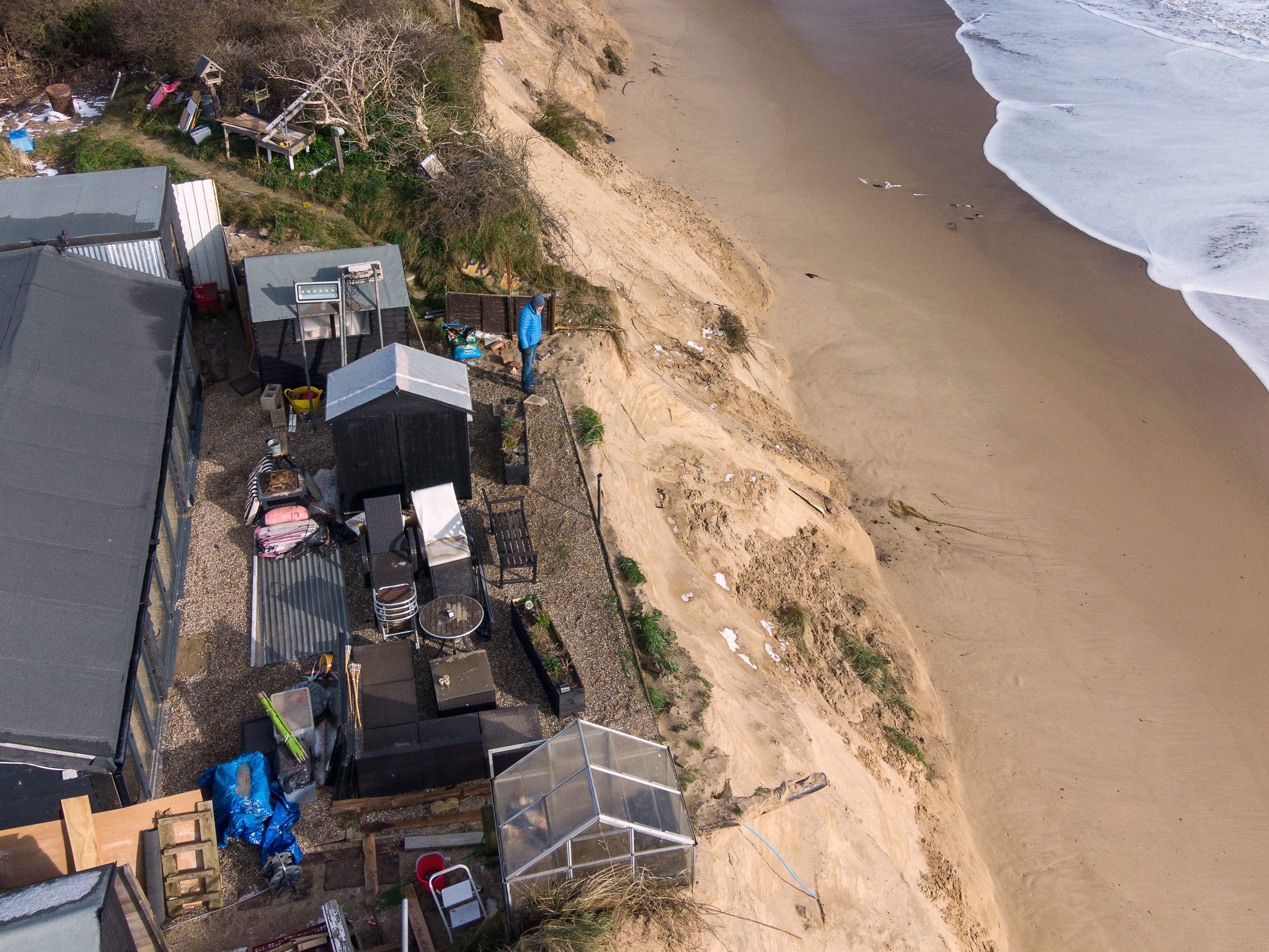 Martin stands in the back garden of his home in Hemsby, Norfolk, where his back door is now no more than 20ft from the cliff edge