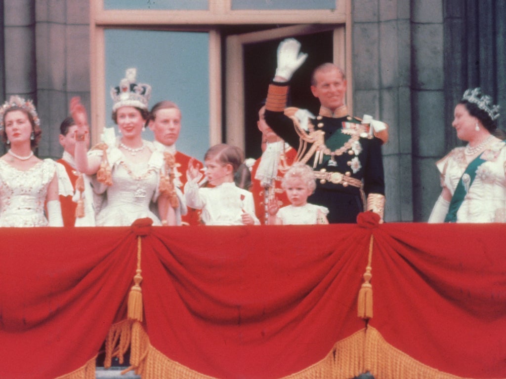 2 June 1953: The Duke of Edinburgh and the newly crowned Queen Elizabeth II wave to the crowd from the balcony at Buckingham Palace. Her children Prince Charles and Princess Anne stand with her