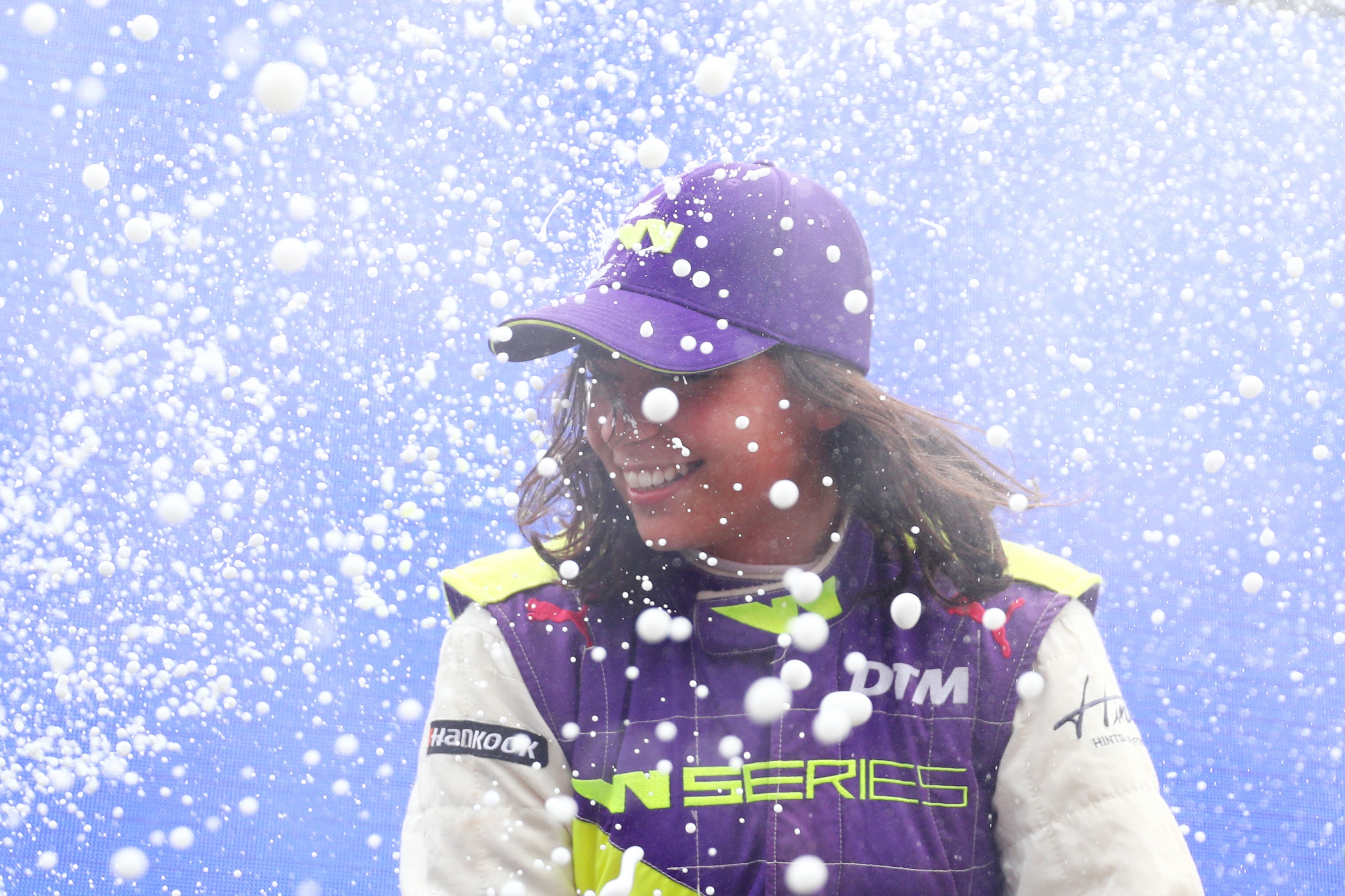 Jamie Chadwick celebrates on the podium after winning the inaugural W Series Championship at Brands Hatch in August 2019