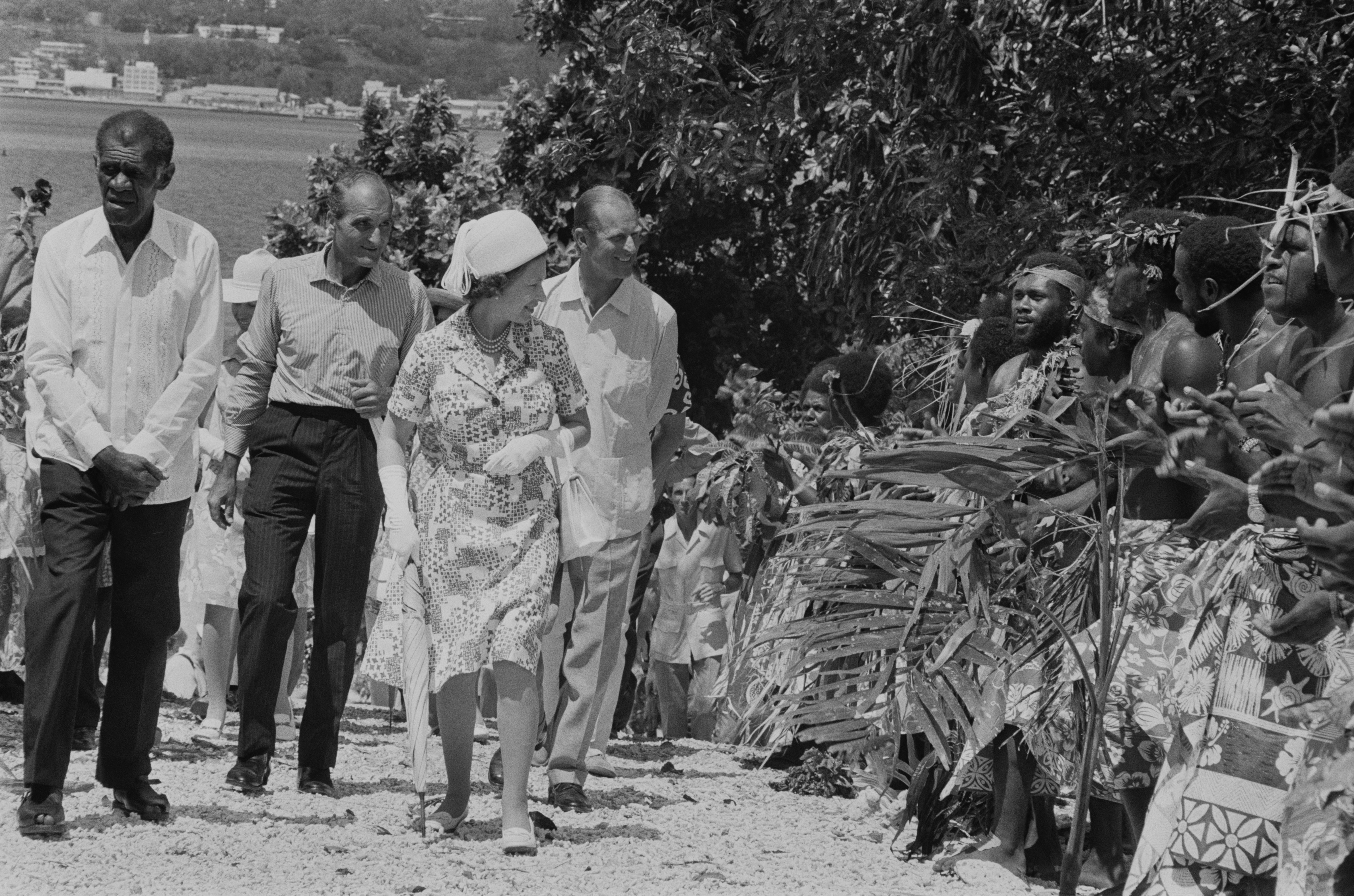 Men in traditional dress line the road during a visit by Queen Elizabeth and Prince Philip to Port Vila, Vanuatu