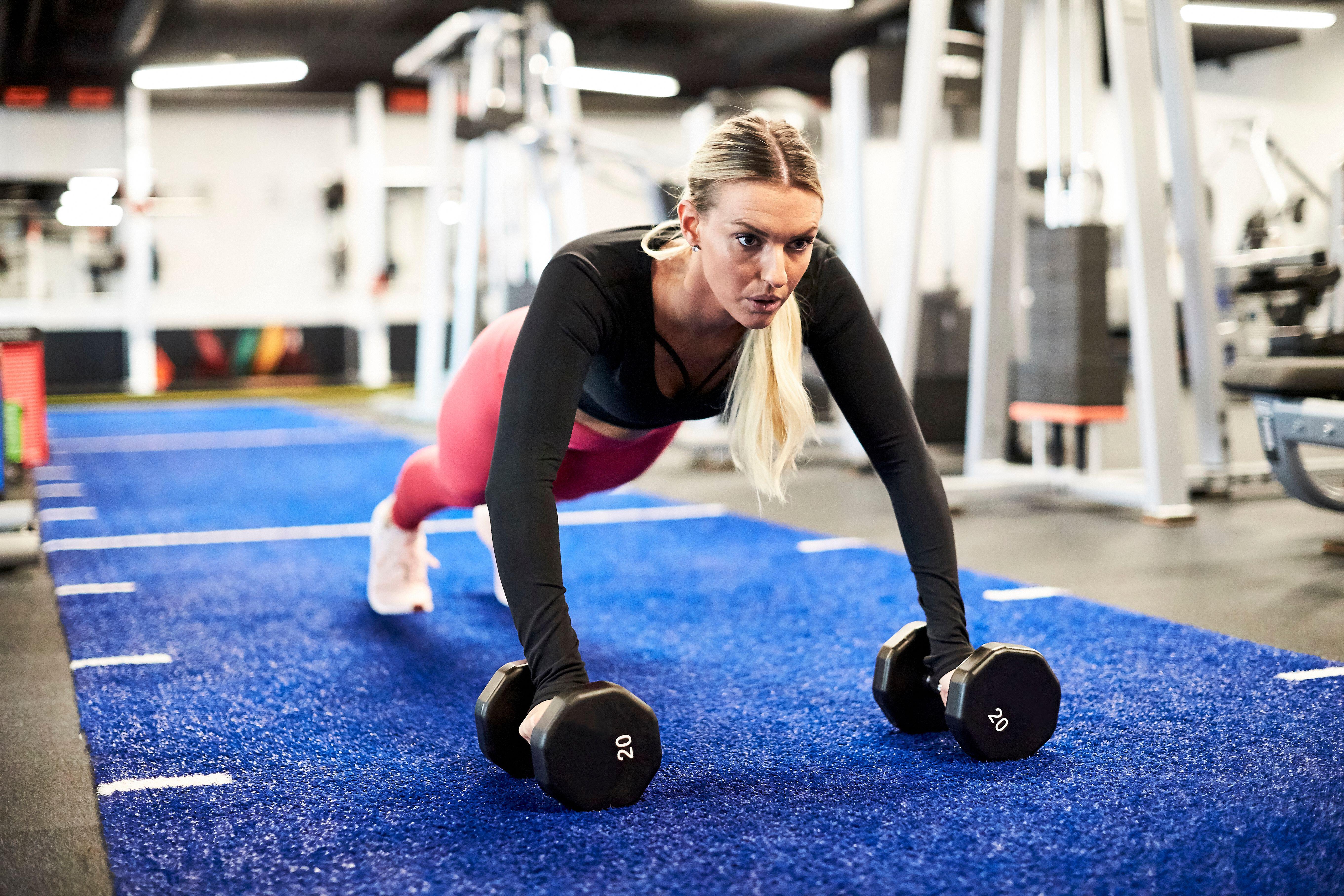 A woman doing push ups at the gym.