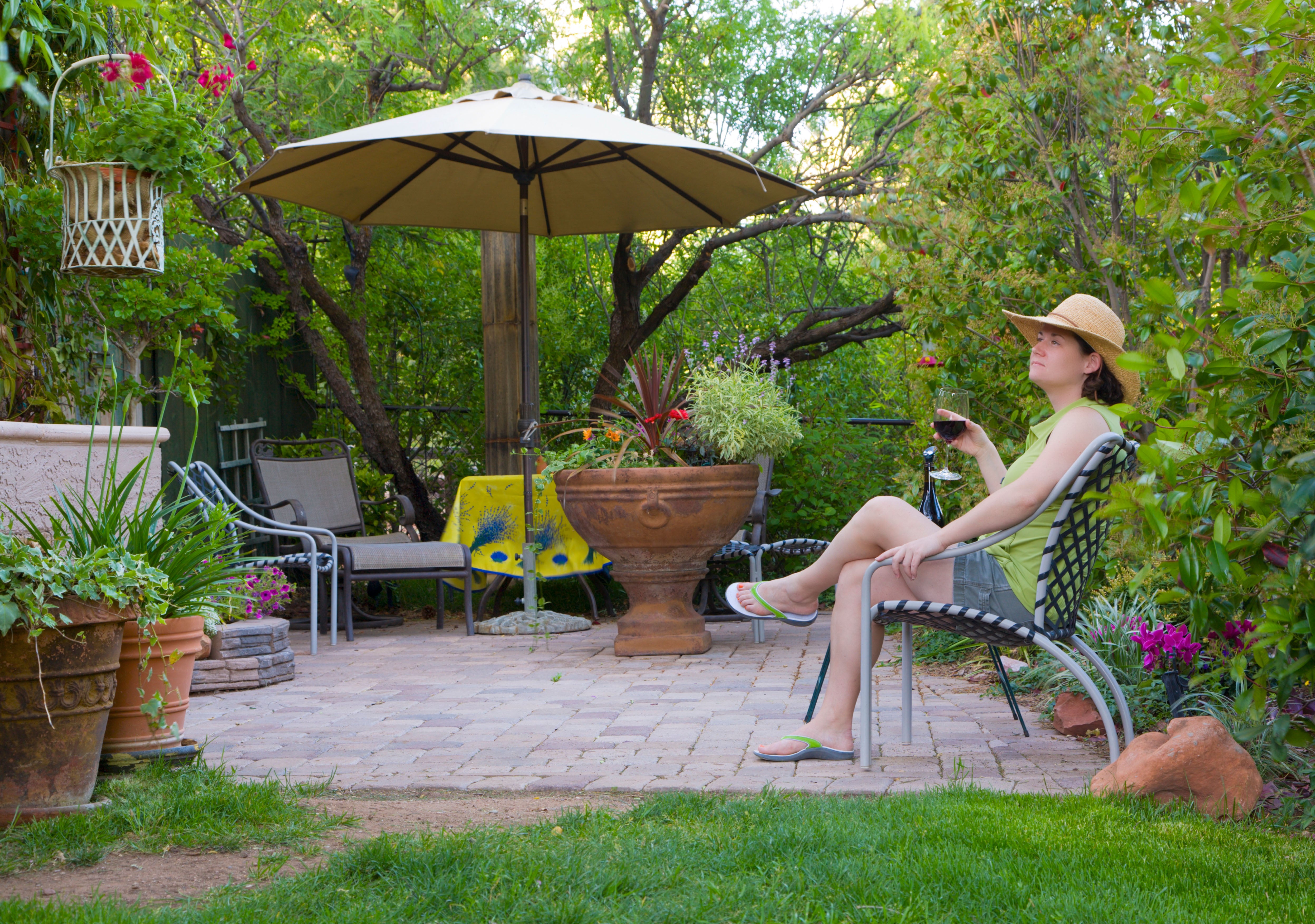 Woman relaxing in the garden with glass of wine