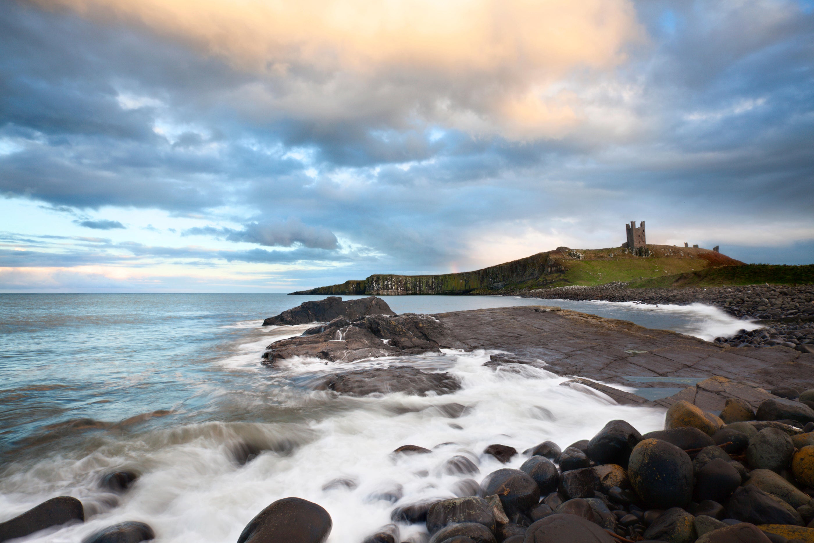 Greymare Rock and Dunstanburgh Castle at Dusk Northumberland Coast England