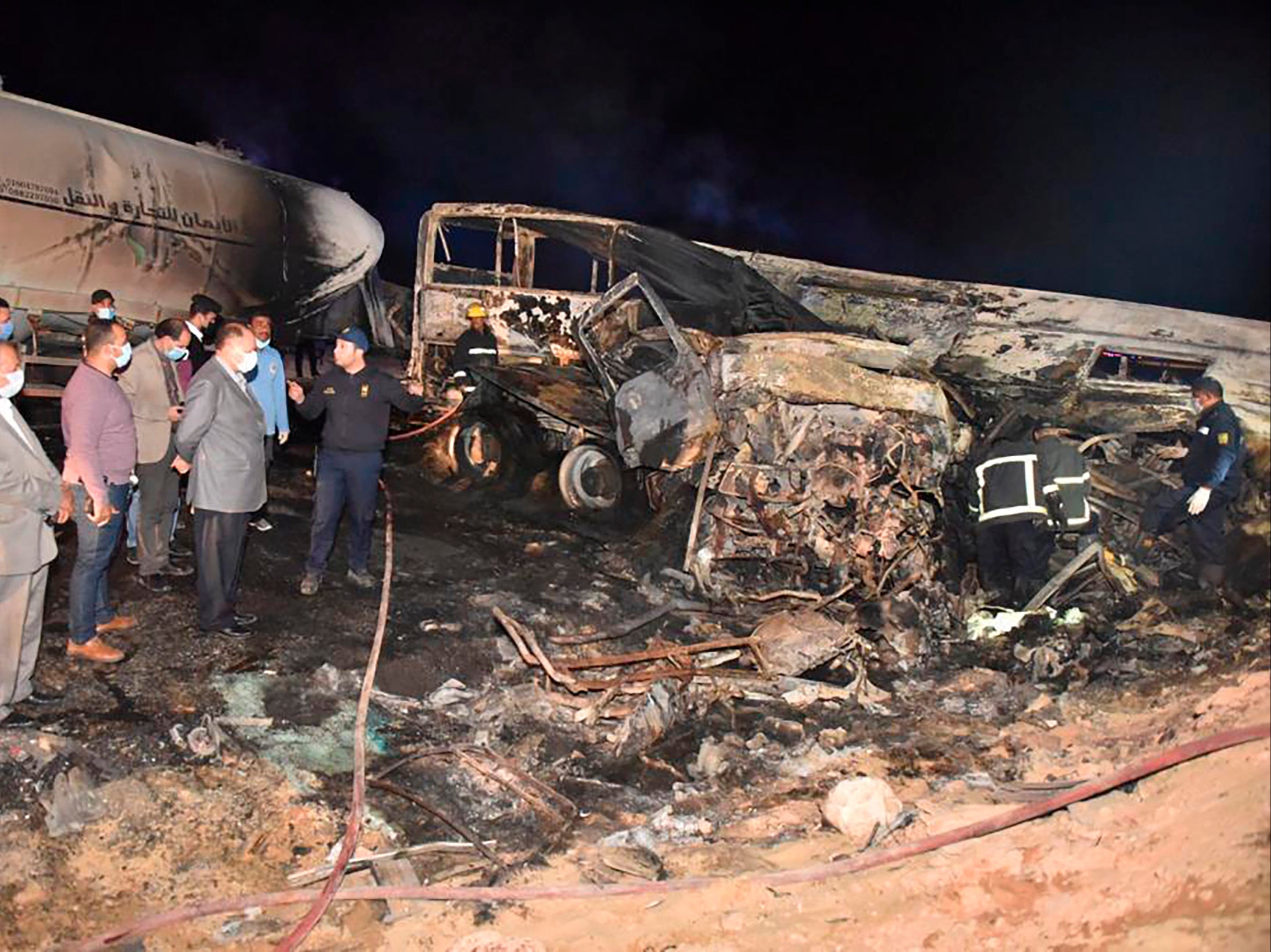 Investigators at the collision site where a bus overturned and burst into flames, killing 20 people, near Assuit, in southern Egypt.