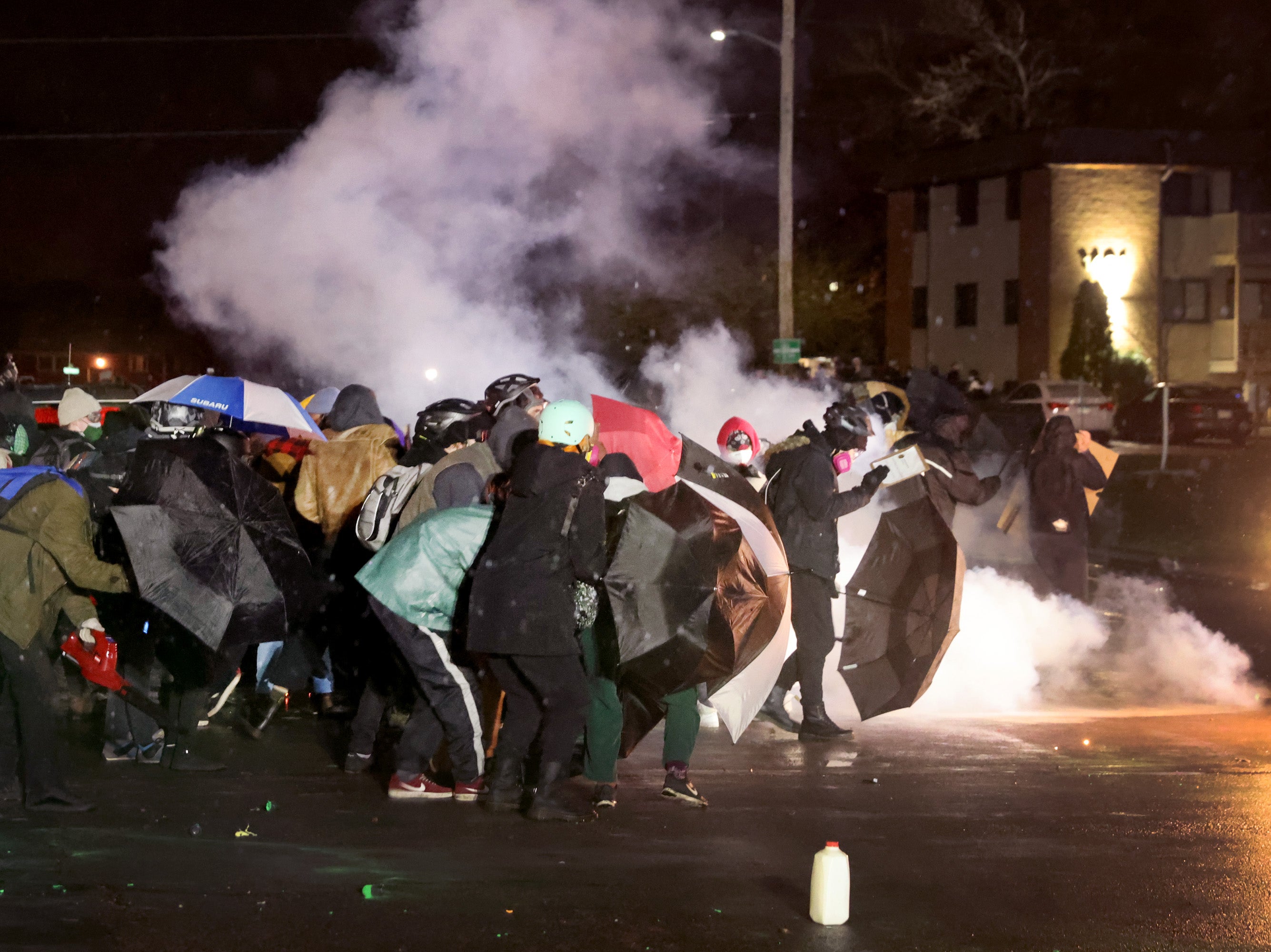 Demonstrators protesting the shooting death of Daunte Wright face-off with police near the Brooklyn Center police station on 13 April 2021