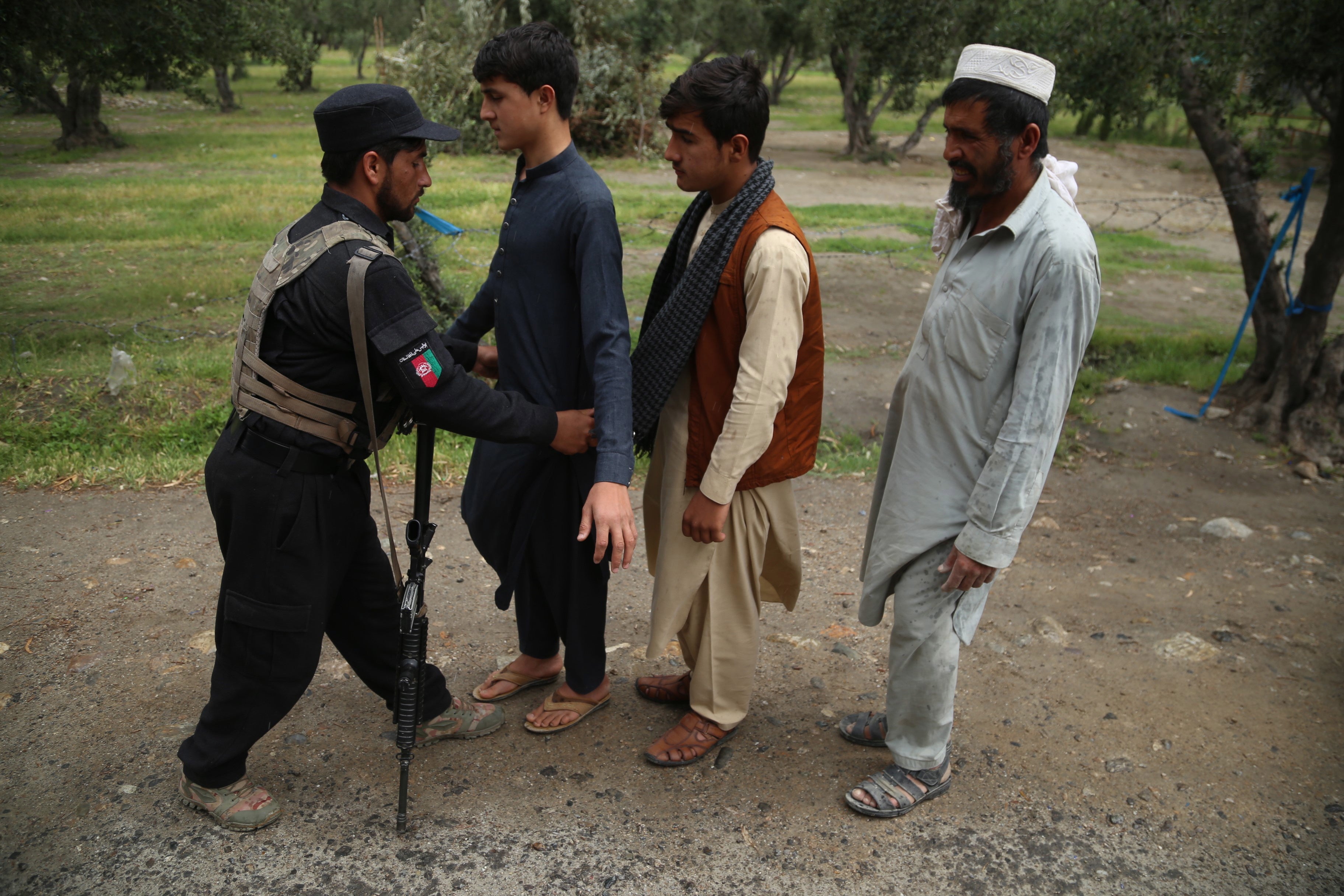 Afghan security official check people at a checkpoint in Jalalabad, 15 April 2021