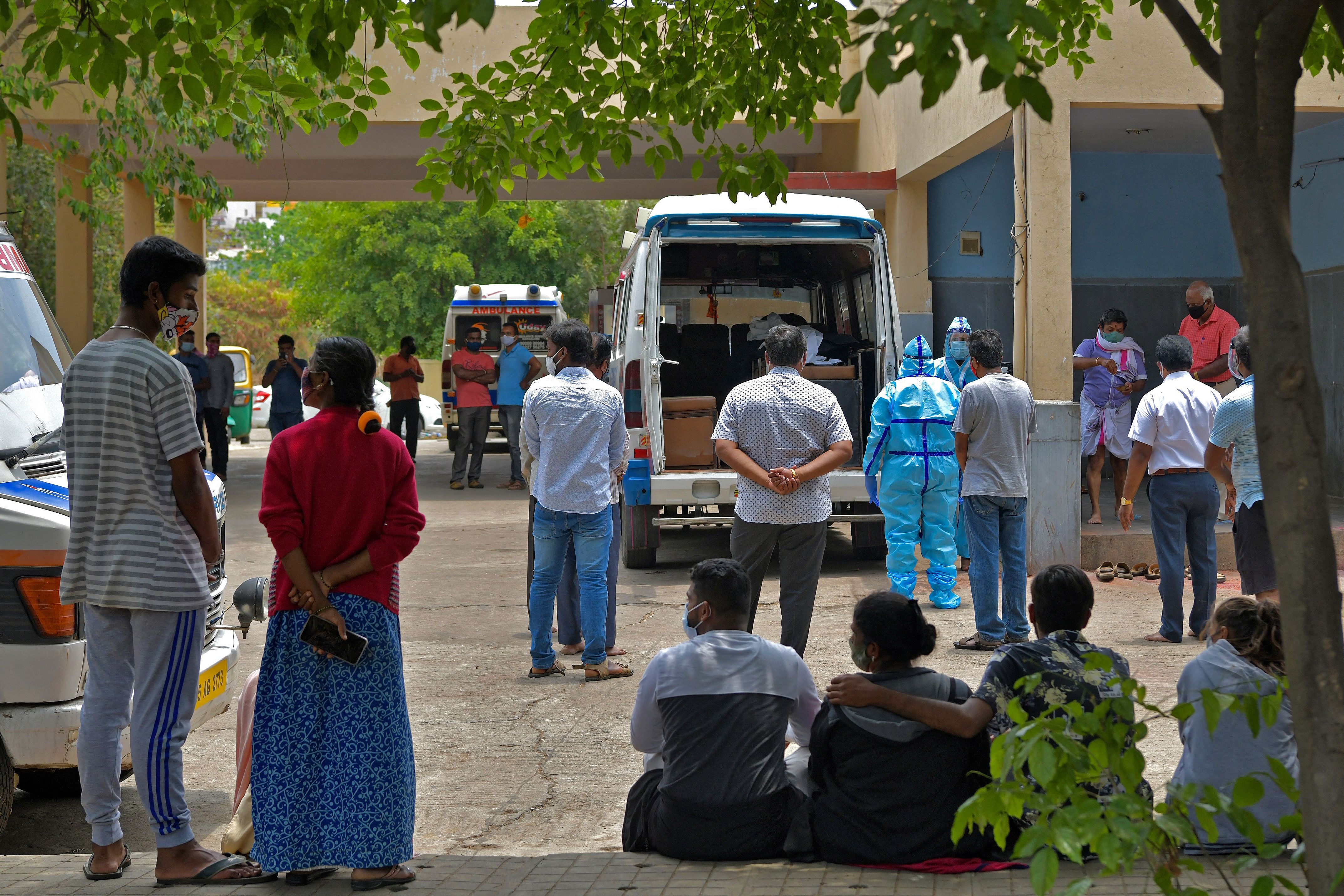 Family members carry out last rites of patients who died of COVID-19 at a hospital in Bengaluru, India