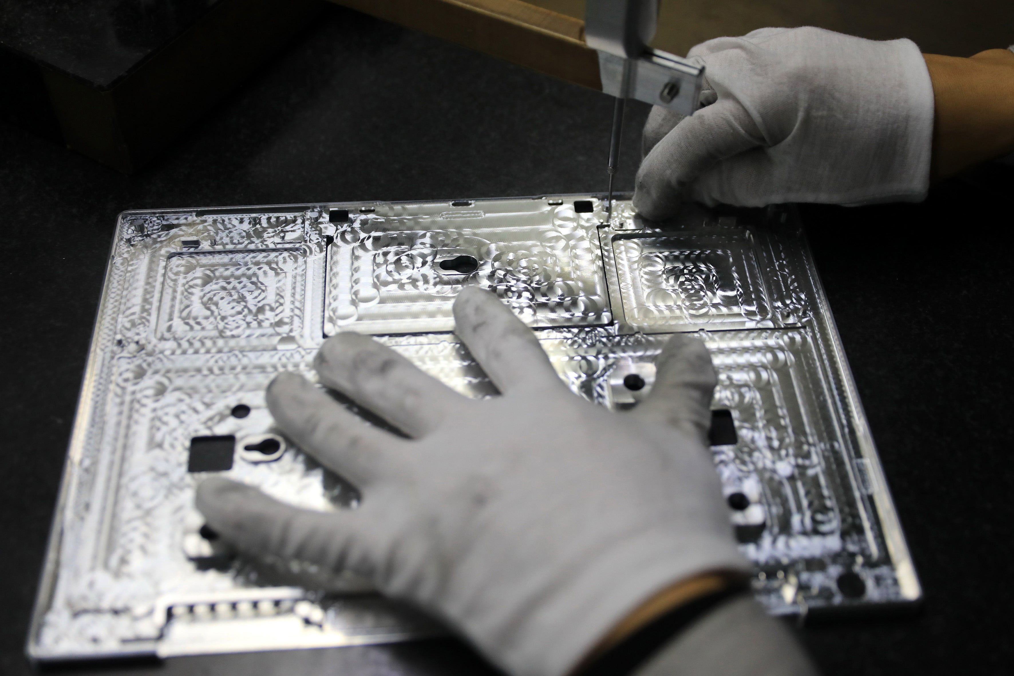 A worker checking laptop parts at a Chinese semiconductor factory