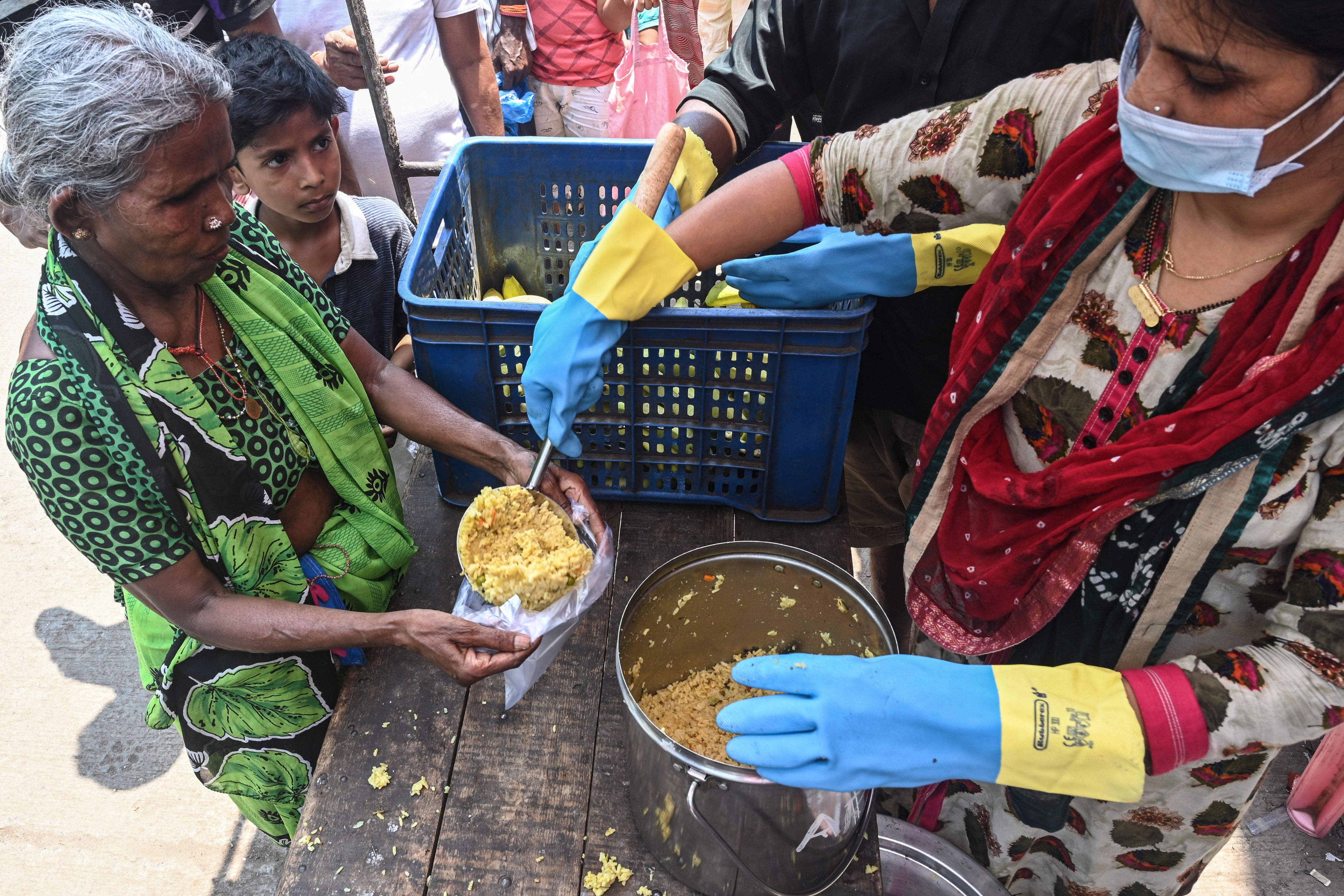 A volunteer distributes food to people in need during the lockdown restrictions