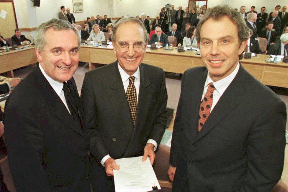 Tony Blair, US Senator George Mitchell (centre) and Irish PM Bertie Ahern smiling after they signed a historic agreement for peace in Northern Ireland in 1998, ending a 30-year war