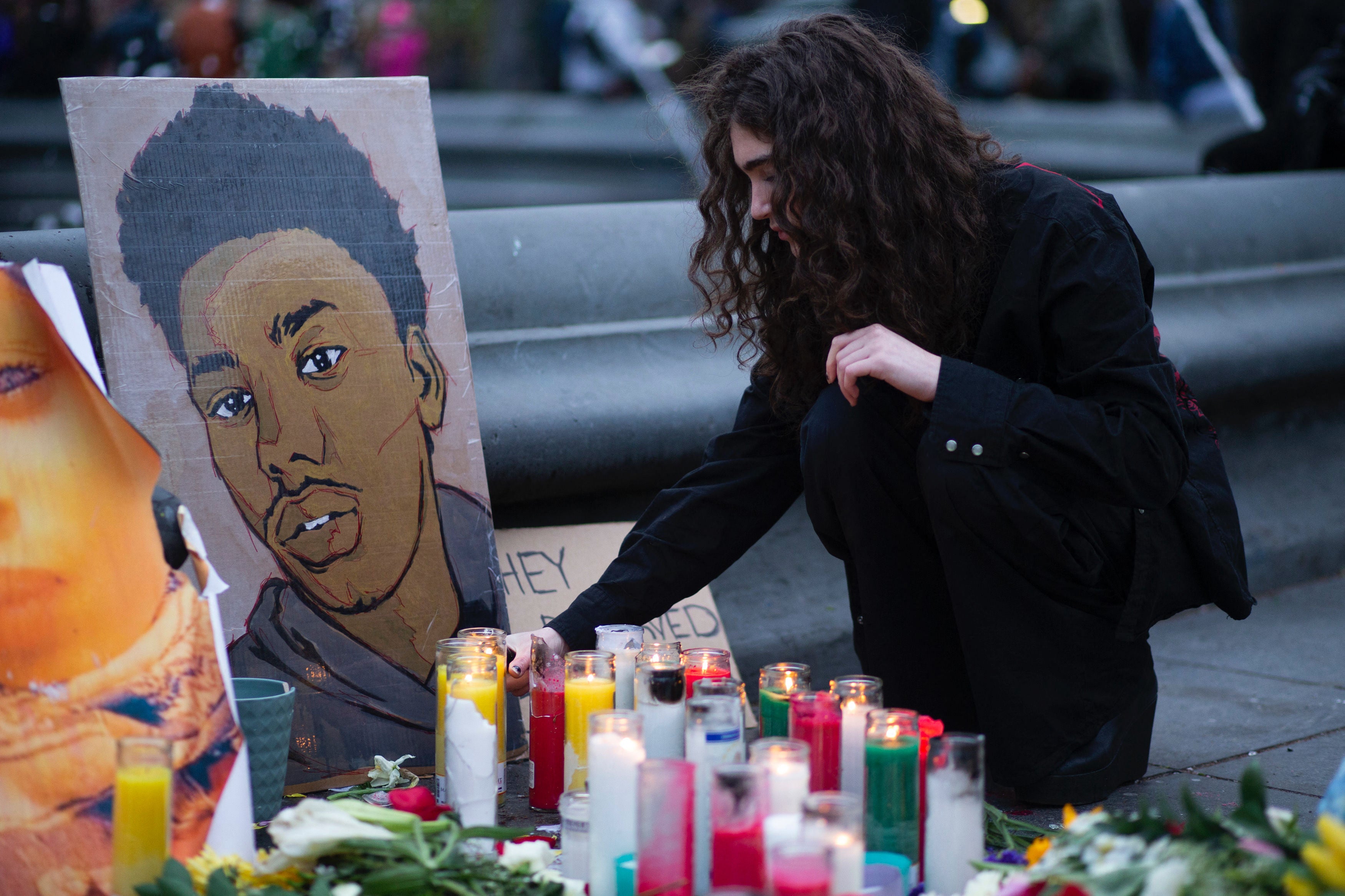 A woman places a candle at a makeshift memorial in honor of Daunte Wright, who was shot dead by a police officer in Minnesota, in Washington Square, New York on April 17, 2021. Kim Potter, the police officer who shot dead Black 20-year-old Daunte Wright in a Minneapolis suburb after appearing to mistake her gun for her taser, was arrested on April 14 on manslaughter charges.