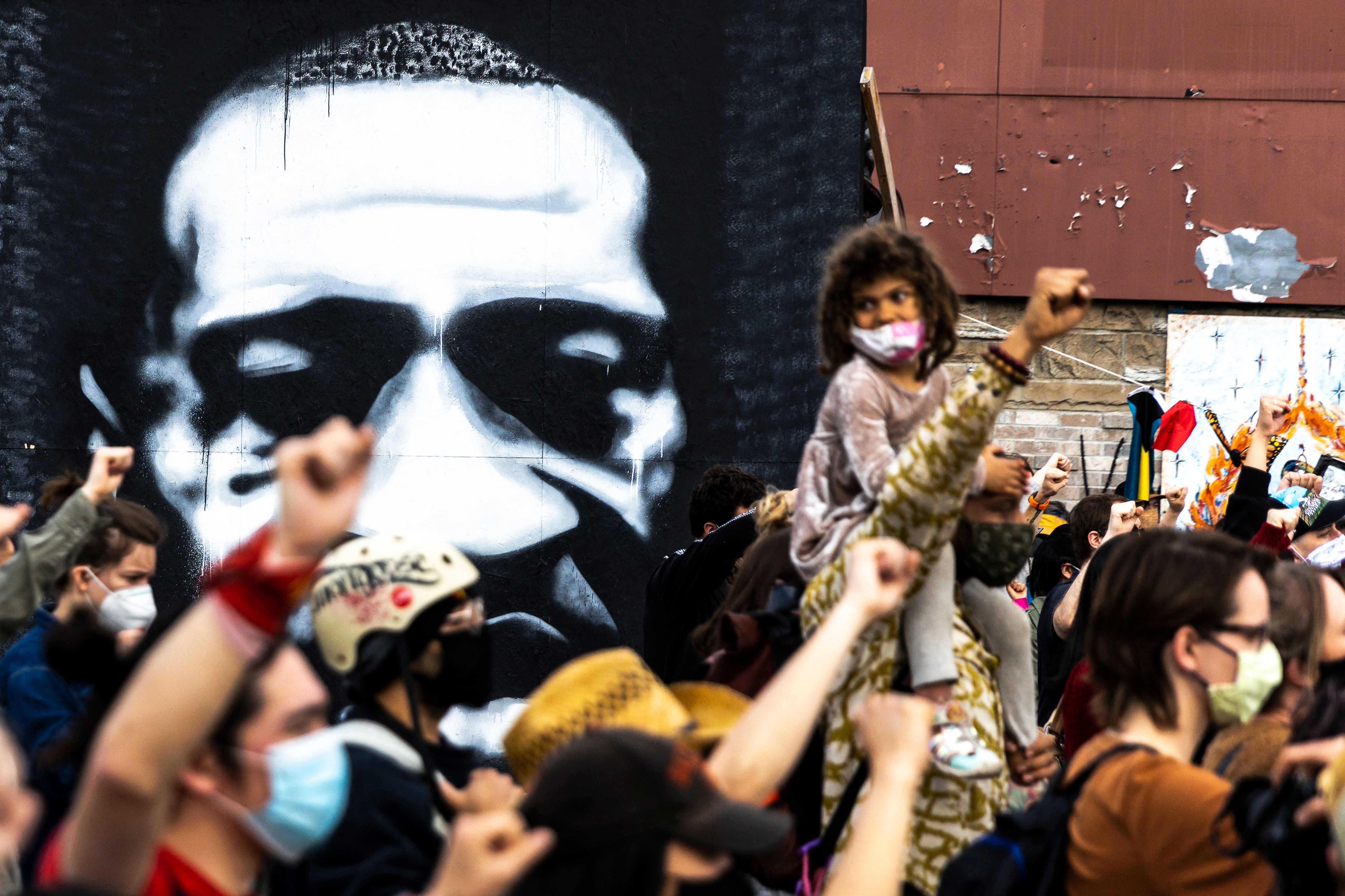 People raise their fists during a demonstration near the George Floyd Memorial in Minneapolis, Minnesota on 18 April 2021 after the shooting death of Daunte Wright