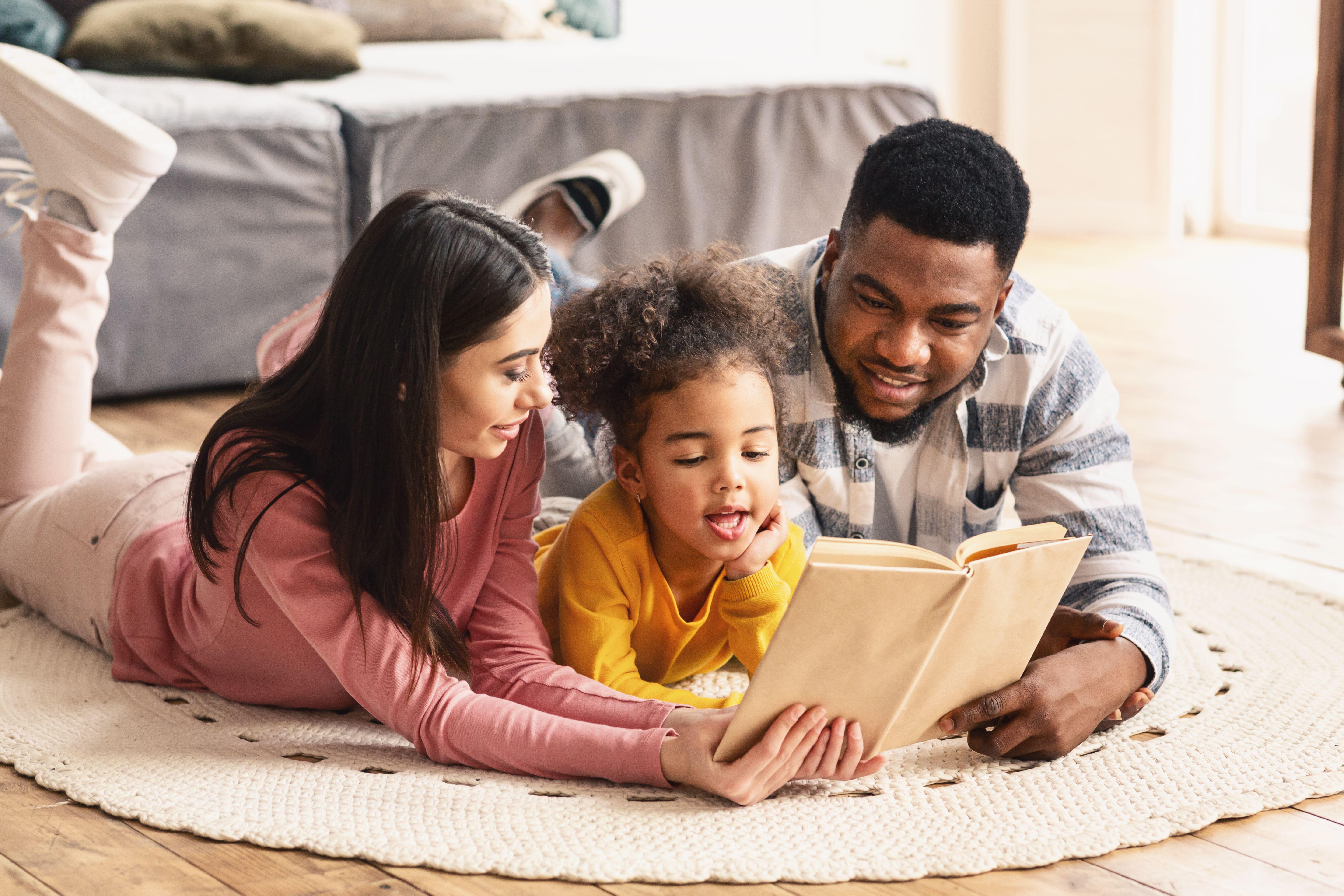 family reading book on the floor