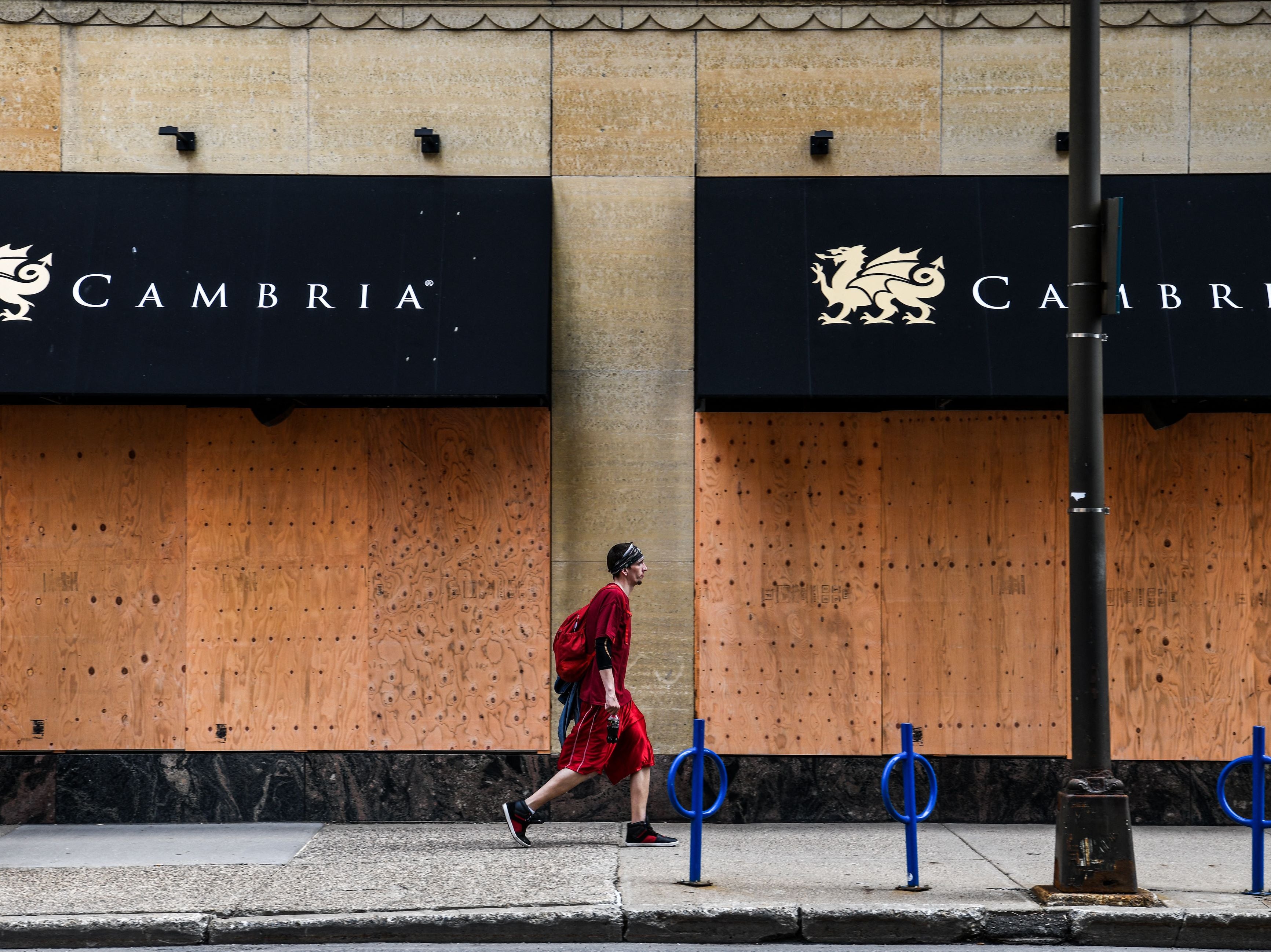 A man walks past a boarded business center near the Hennepin County Government Center in Minneapolis, Minnesota on 18 April, 2021