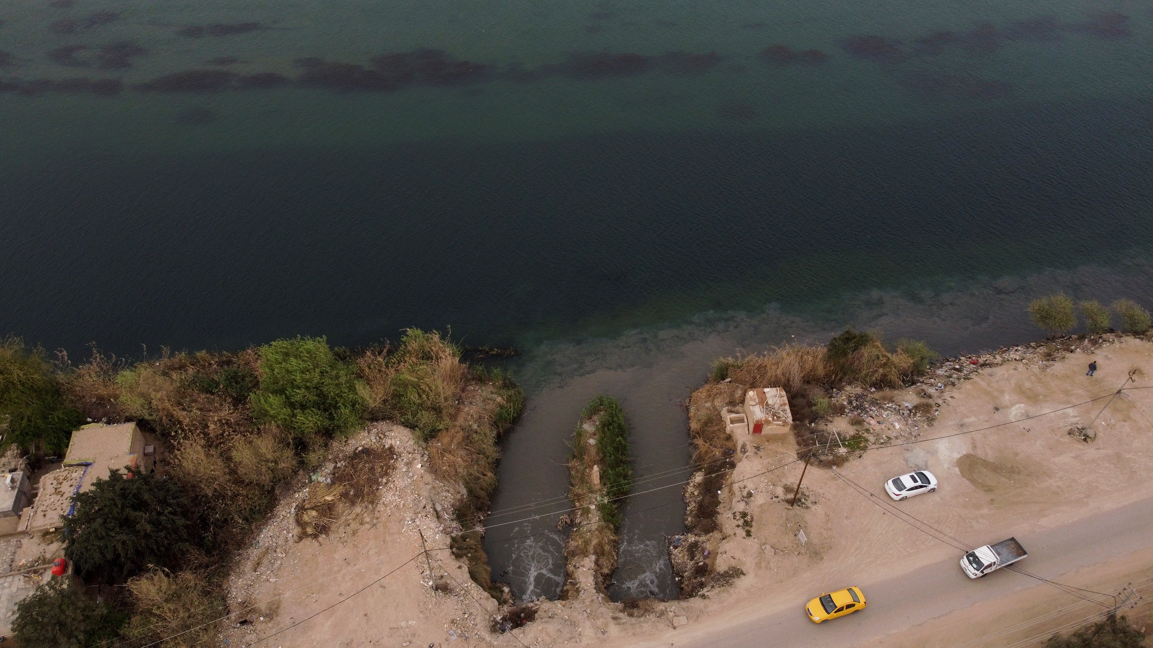 A drain pipe carries raw sewage into the Euphrates River, near Najaf, Iraq