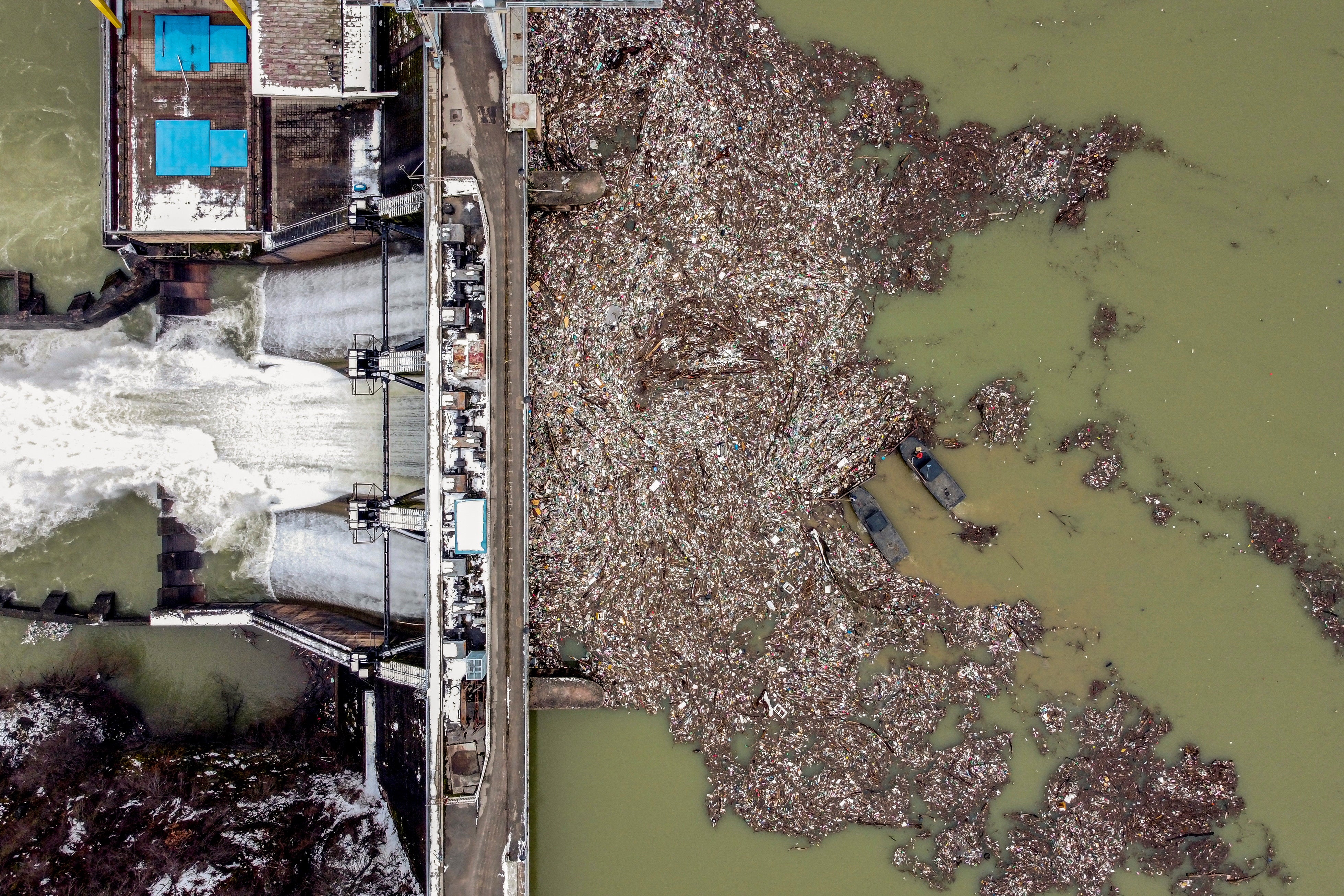 Workers collect plastic from the polluted Potpecko Lake near the town of Priboj, Serbia