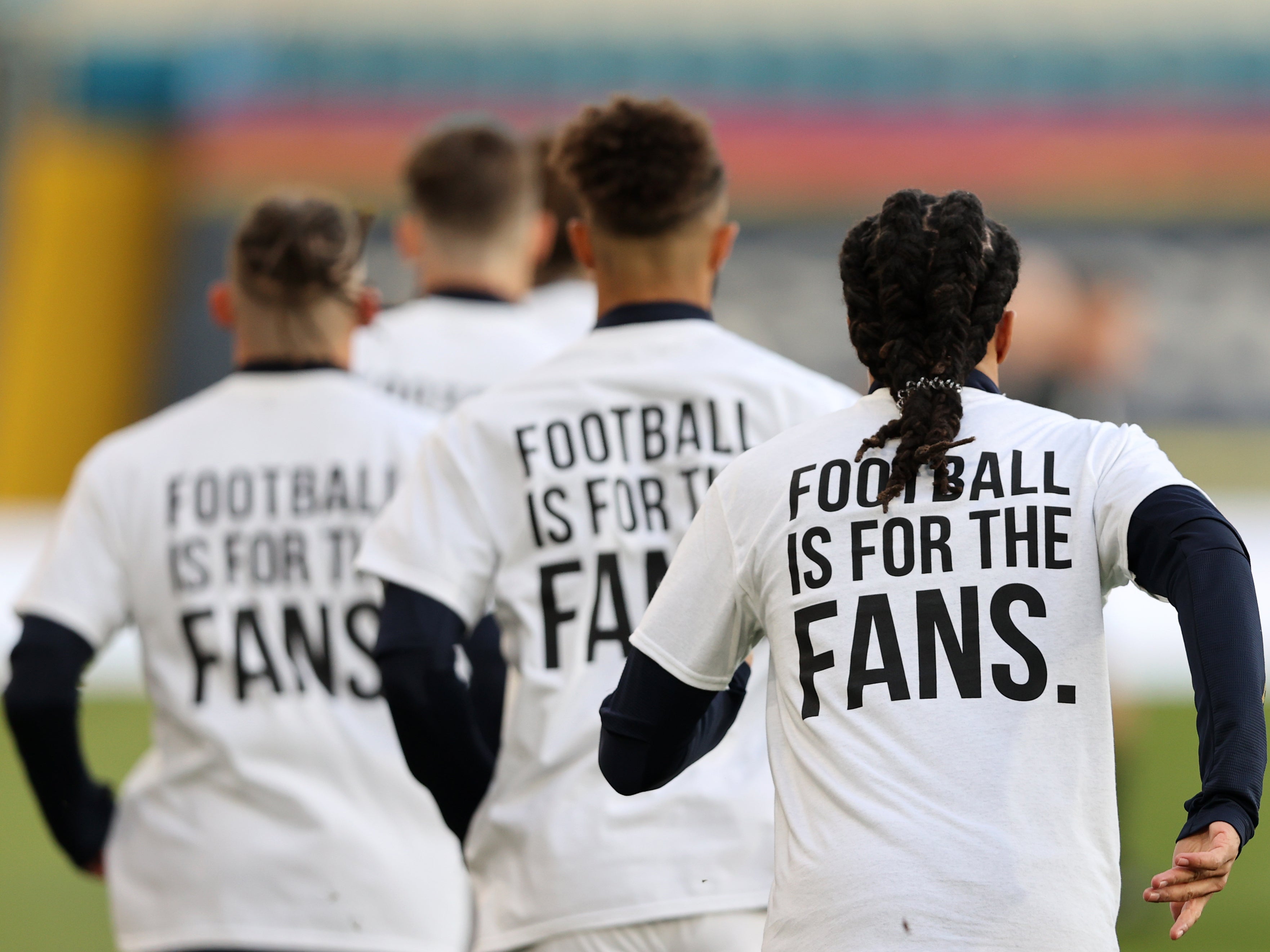 Players of Leeds United warm up while wearing protest t-shirts