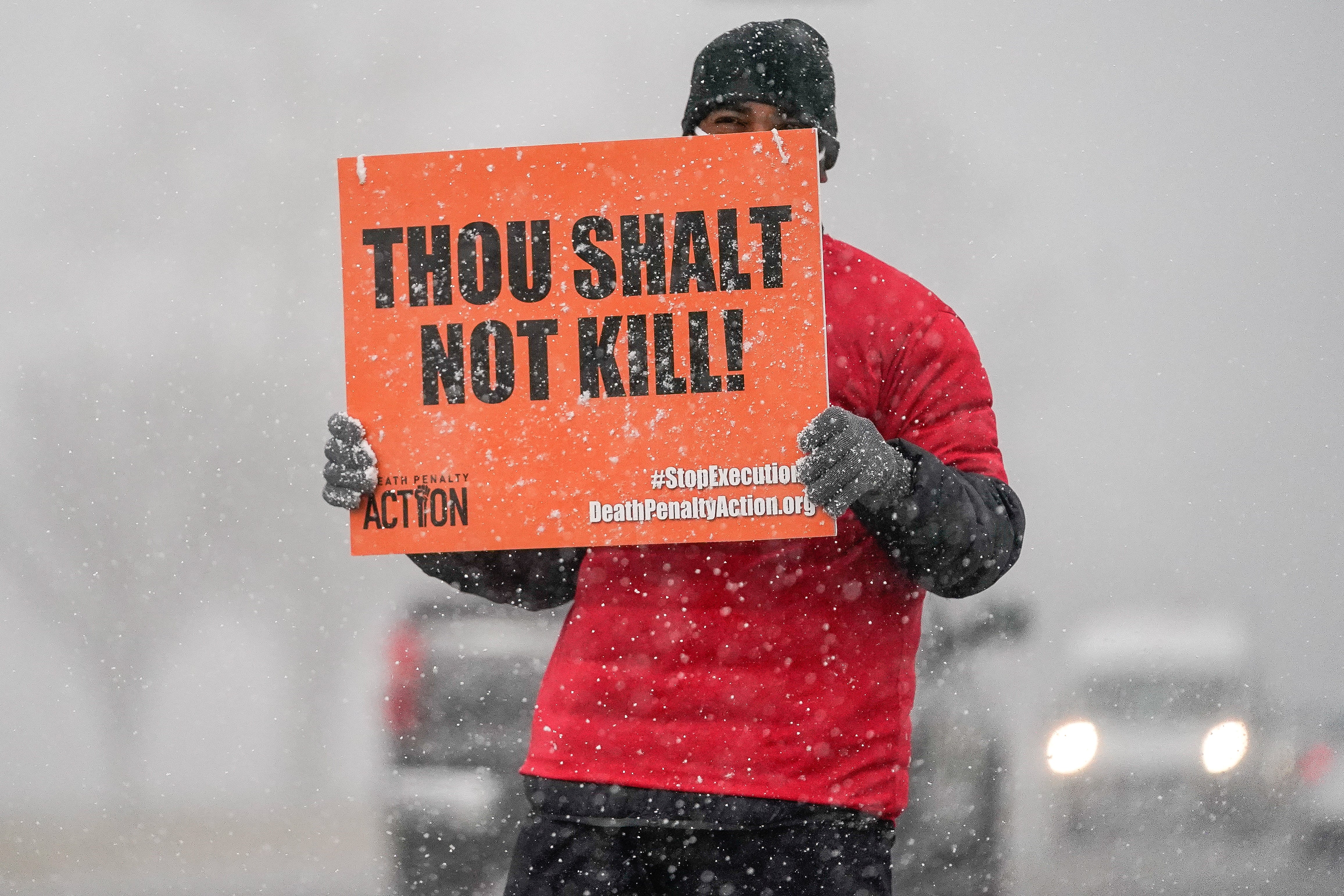 An activist holding a sign in opposition to the death penalty outside of the United States Penitentiary in Terre Haute, Indiana