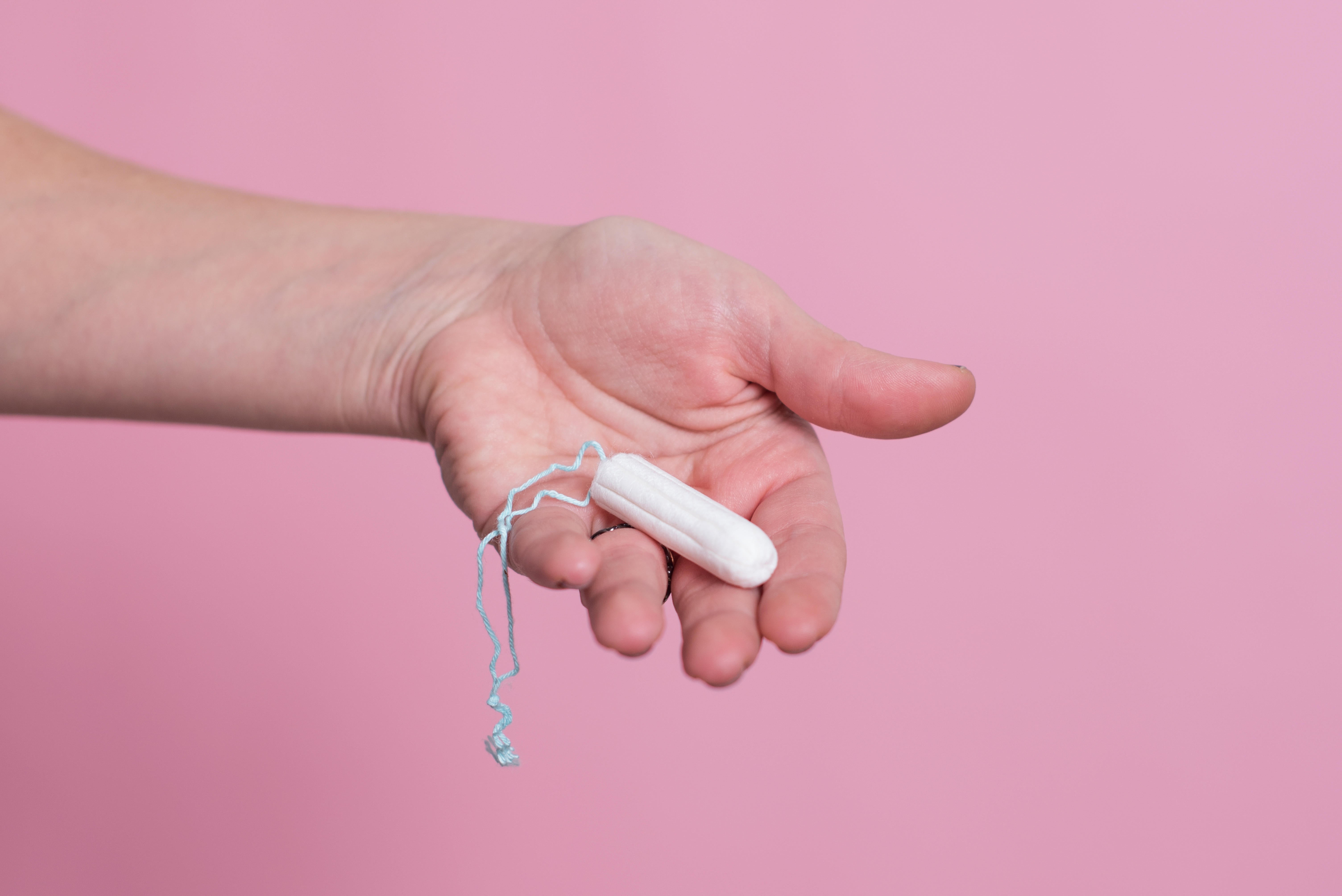 Woman's hand holding a clean cotton tampon