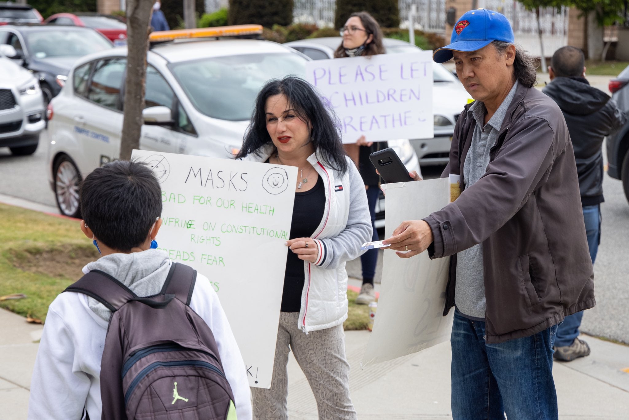 A photo posted on Twitter by journalist Samuel Braslow showing anti-mask protesters outside Hawthorne Elementary School in Beverly Hills on Wednesday