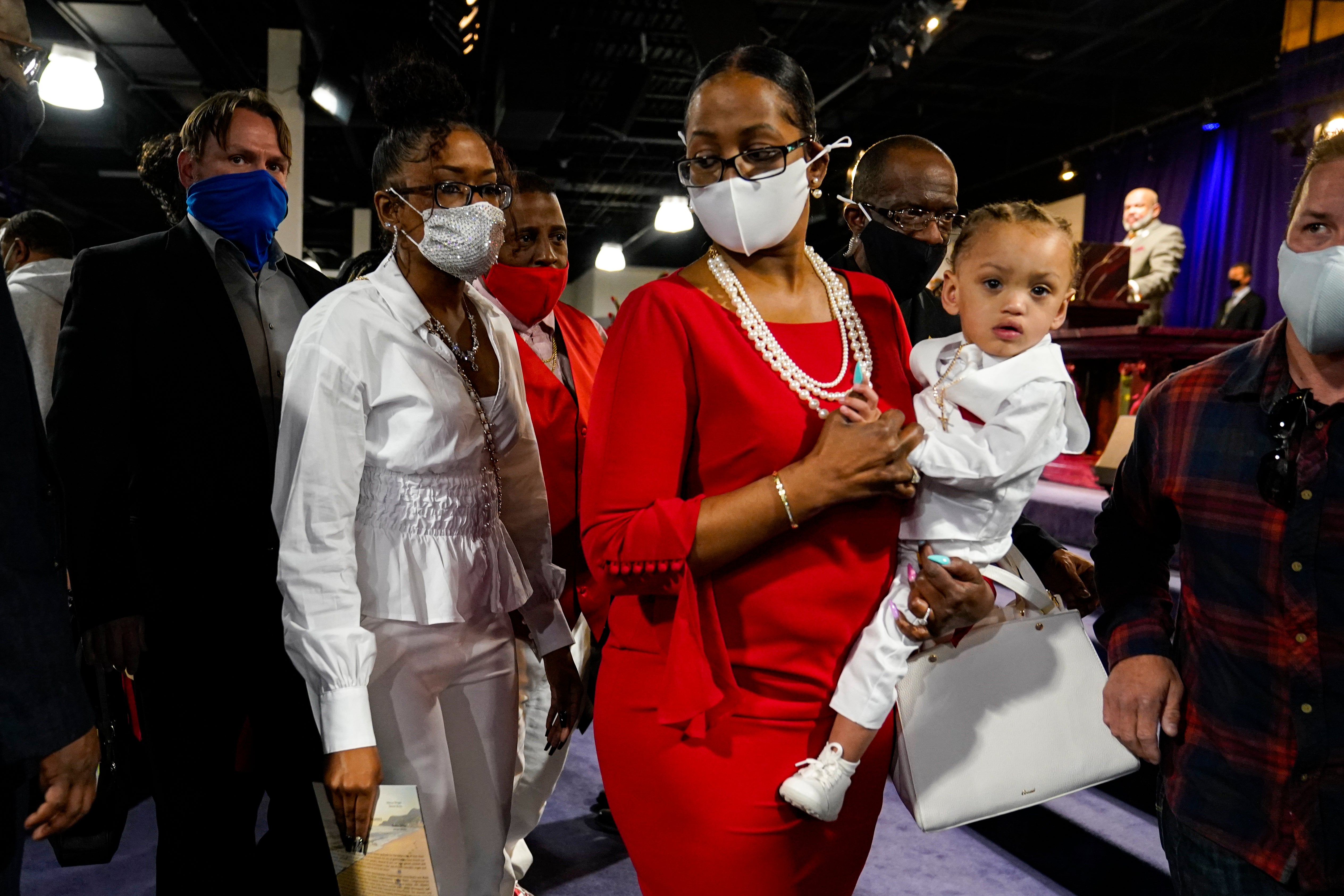 Daunte Wright's son, Daunte Wright Jr., is carried by grandmother Erica Whitaker, as she leads her daughter Chyna Whitaker, into the funeral services for Daunte Wright at Shiloh Temple International Ministries in Minneapolis